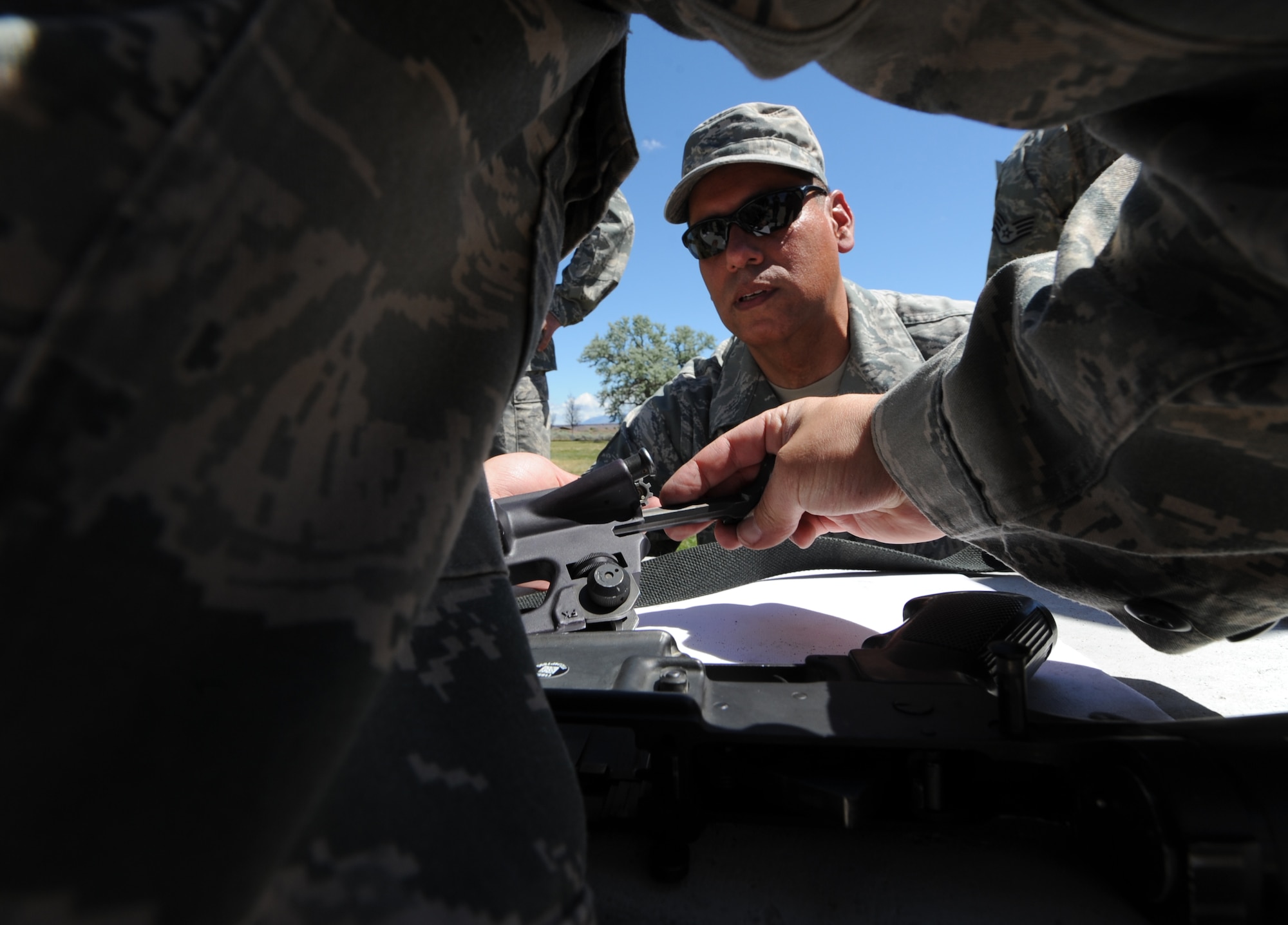 BRUNEAU STATE PARK, Idaho – Chief Master Sgt. Leonardo Rodriguez, 726th Air Control Squadron chief enlisted manager, gives instructions on how to assemble an M-16 rifle to a blindfolded Airman during a timed training exercise at Bruneau State Park June 3. During the field training exercise Airmen were broken up into 10 teams and completed a 1.5-mile course while each member carried a 30-pound rucksack and each team carried a 200-pound dummy. The team-building exercise helps the 726th ACS maintain a combat ready status in order to provide air battle management to joint air, land and sea power at a moment’s notice. (U.S. Air Force photo by Senior Airman Debbie Lockhart)