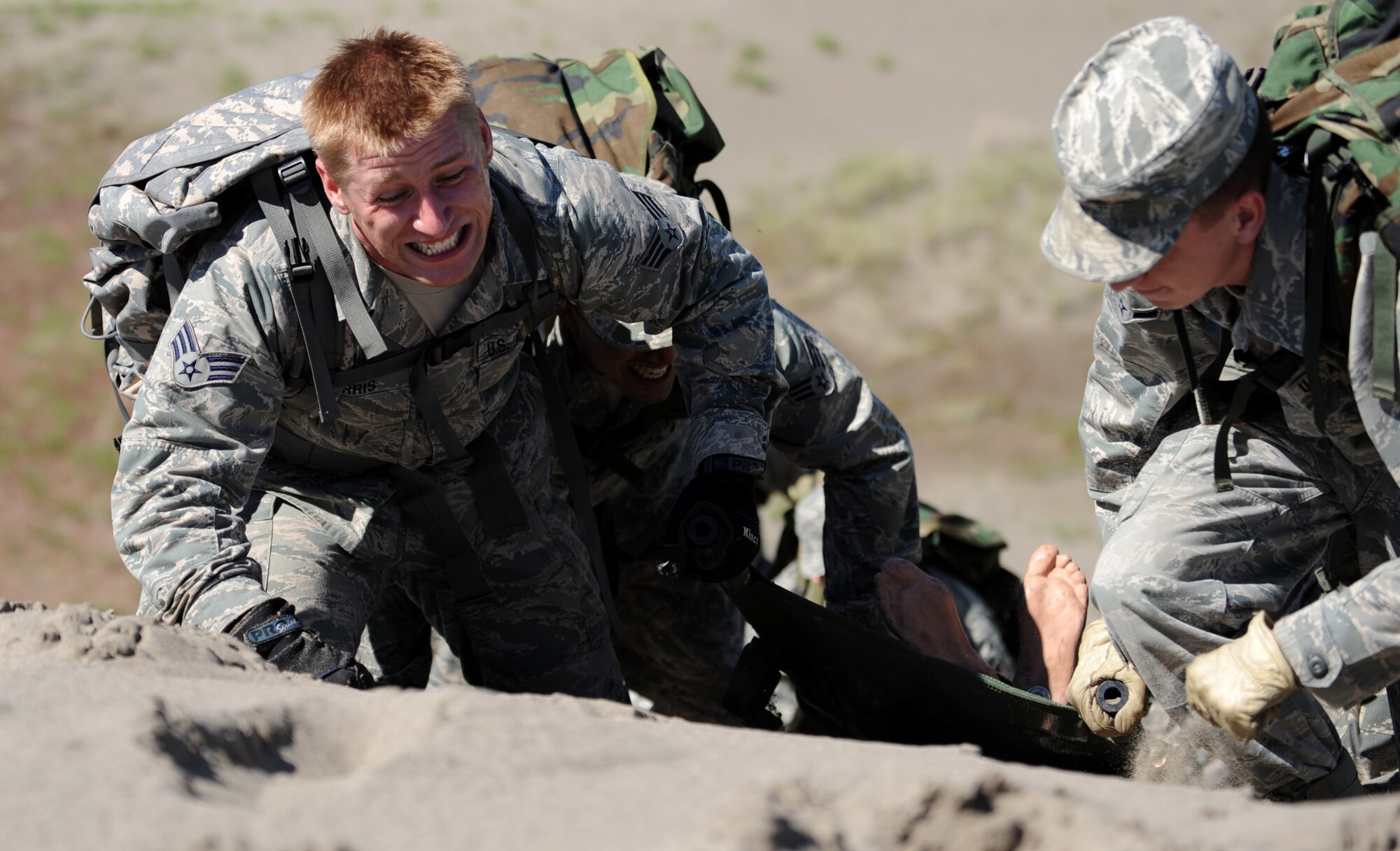 BRUNEAU STATE PARK, Idaho – Senior Airman Bryan Morris, 726th Air Control Squadron transmission systems journeyman, carries a 200-pound dummy to the top of a sand dune with his teammates during a training exercise at Bruneau State Park June 3. During the field training exercise Airmen were broken up into 10 teams and completed a 1.5-mile course while each member carried a 30-pound rucksack. The exercise helps the squadron maintain their combat ready status. The squadron is made up of 27 different Air Force career fields making it self-sustaining and able to deploy and fully operate without external support or help. (U.S. Air Force photo by Senior Airman Debbie Lockhart)