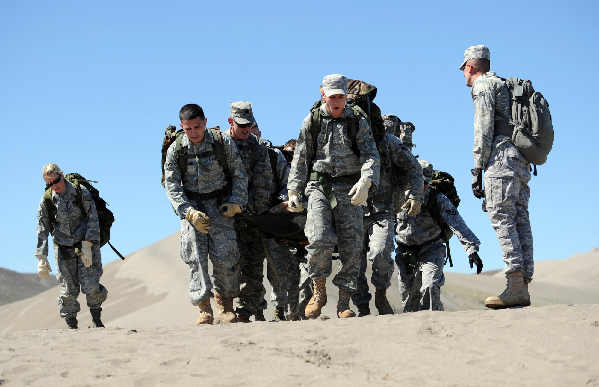 BRUNEAU STATE PARK, Idaho – A team of Airmen from the 726th Air Control Squadron carry a 200-pound dummy to the top of a sand dune while completing a 1.5-mile course during a training exercise at Bruneau State Park June 3. This team-building exercise helps the 726th ACS to maintain a combat ready status in order to provide air battle management to joint air, land and sea power at a moment’s notice. (U.S. Air Force photo by Senior Airman Debbie Lockhart)