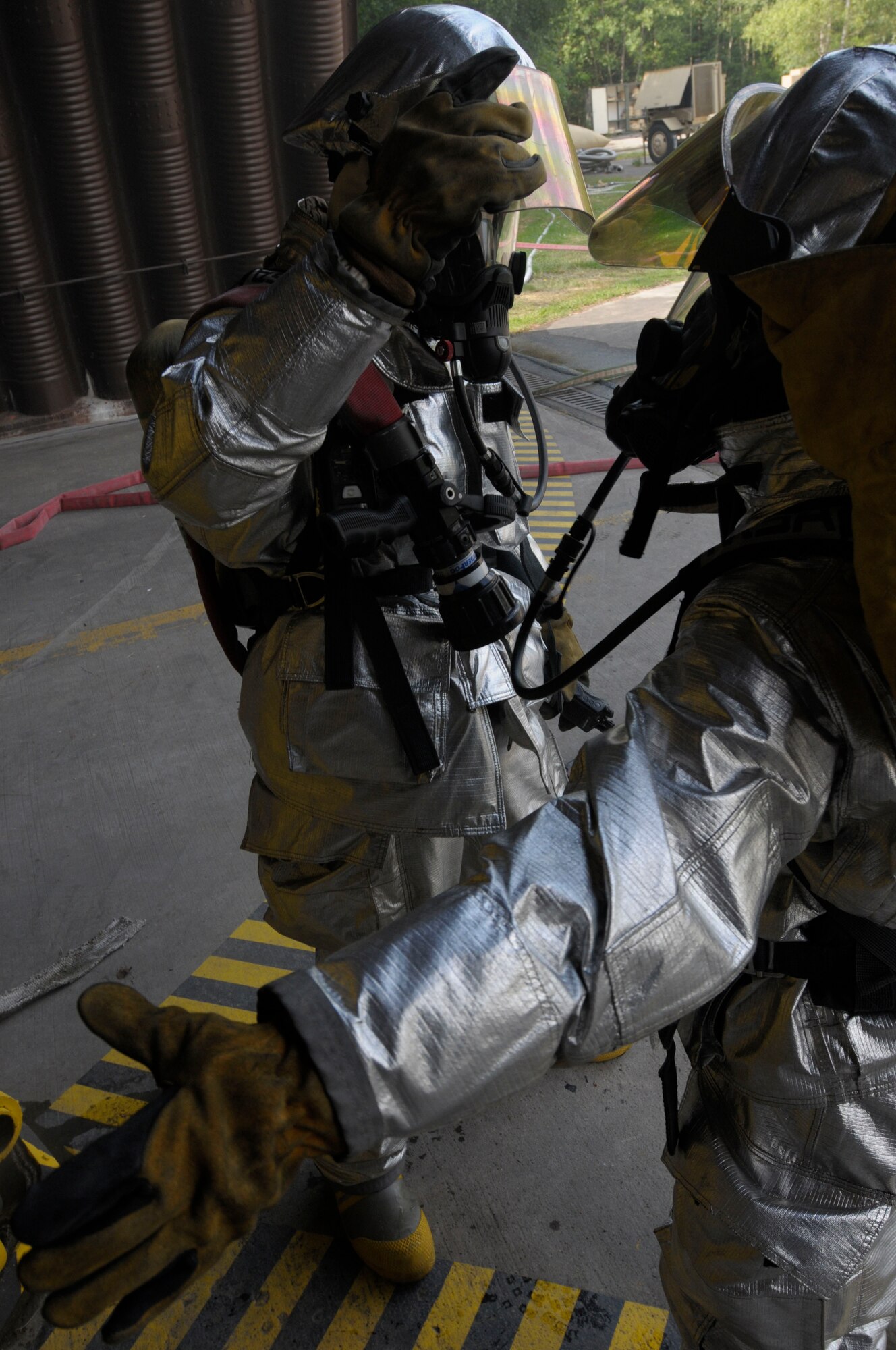 U.S. Air Force Staff Sgt. Brent Watkins and Airman 1st Class Ronald Brown, 31st Civil Engineer Squadron, Aviano Air Base, Italy, conduct buddy checks before entering a simulated fire during Silver Flag, Ramstein Air Base, Germany, June 7, 2011. Silver Flag is a weeklong training program for Airmen from various bases; it combines classroom and practical application exercises to prepare Airmen for deployment. (U.S. Air Force photo by Airman 1st Class Desiree Esposito)