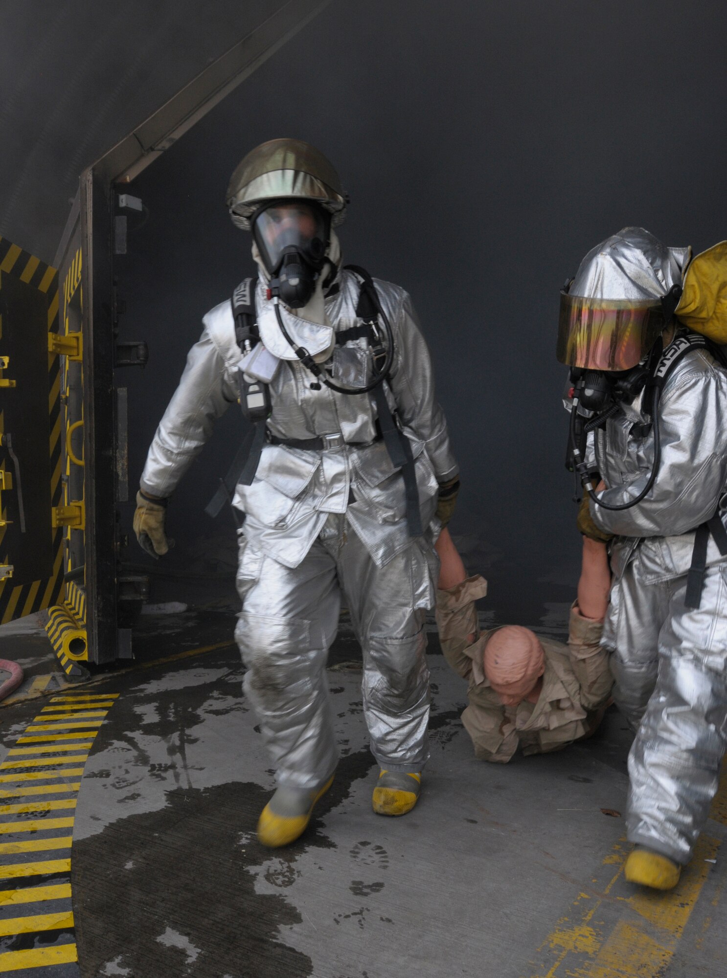 U.S. Air Force Staff Sgt. Brent Watkins and Airman 1st Class Ronald Brown, 31st Civil Engineer Squadron, Aviano Air Base, Italy, rescue an injured victim from a simulated fire during Silver Flag, Ramstein Air Base, Germany, June 7, 2011. The exercise inject consisted of several simulated scenarios that included victim rescue and uncontained fires. Silver Flag is a weeklong training program for Airmen from various bases; it combines classroom and practical application exercises to prepare Airmen for deployment. (U.S. Air Force photo by Airman 1st Class Desiree Esposito)