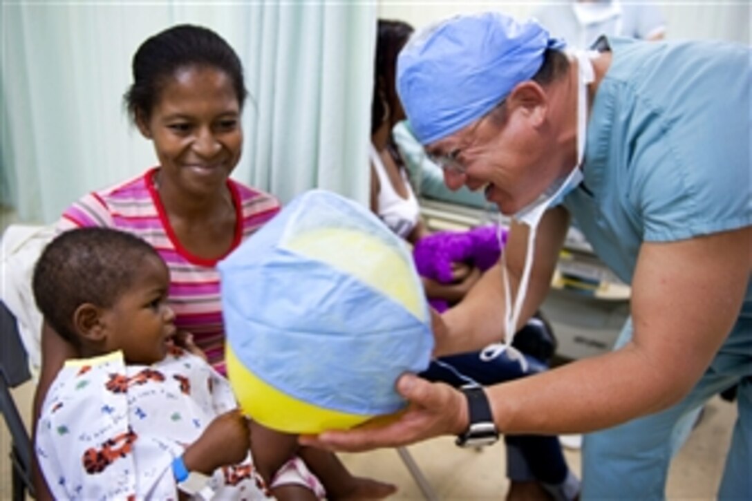 Dr. George Martinez, a surgeon from Ecuador, plays with a patient before performing surgery aboard the hospital ship USNS Comfort in Tumaco, Colombia, June 5, 2011. The Comfort's crew is participating in Continuing Promise 2011, a five-month humanitarian assistance mission to the Caribbean, Central and South America.