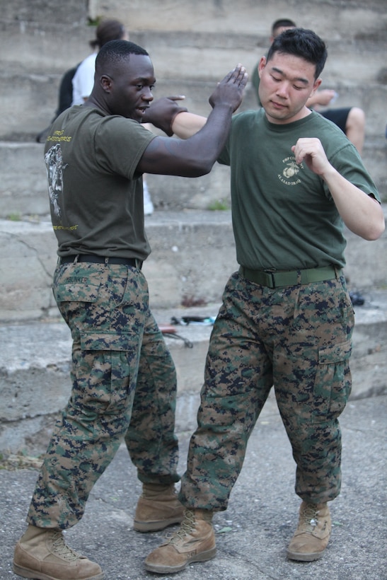 CAMP PEPELISHTE, Macedonia – U.S. Marine Staff Sgt. Tresor Mbunker, 4th Marine Logistics Group, Personnel and Retrieval Processing Company, mortuary affairs staff noncommissioned officer in charge and a black belt Marine Corps Martial Arts instructor out of Smyrna, Ga., demonstrates MCMAP moves on Cpl. Eric Ahn,4th MLG, PRP specialist out of Anacostia, Washington, D.C., for spectators and students June 8.  The Marines came to Macedonia for Medical Training Exercise in Central and Eastern Europe 2011 to teach foreign military services how to conduct mortuary affairs. MEDCEUR is an annual Chairman of the Joint Chiefs of Staff-sponsored regional and multilateral exercise and is designed to provide medical training and operational experience in a deployed environment for U.S. and partner nations. The countries participating in this year’s MEDCEUR are Macedonia, Montenegro, Bosnia and Herzegovina, Serbia, Slovenia and Norway.  The exercise will include both classroom and hands-on training and run until June 15.