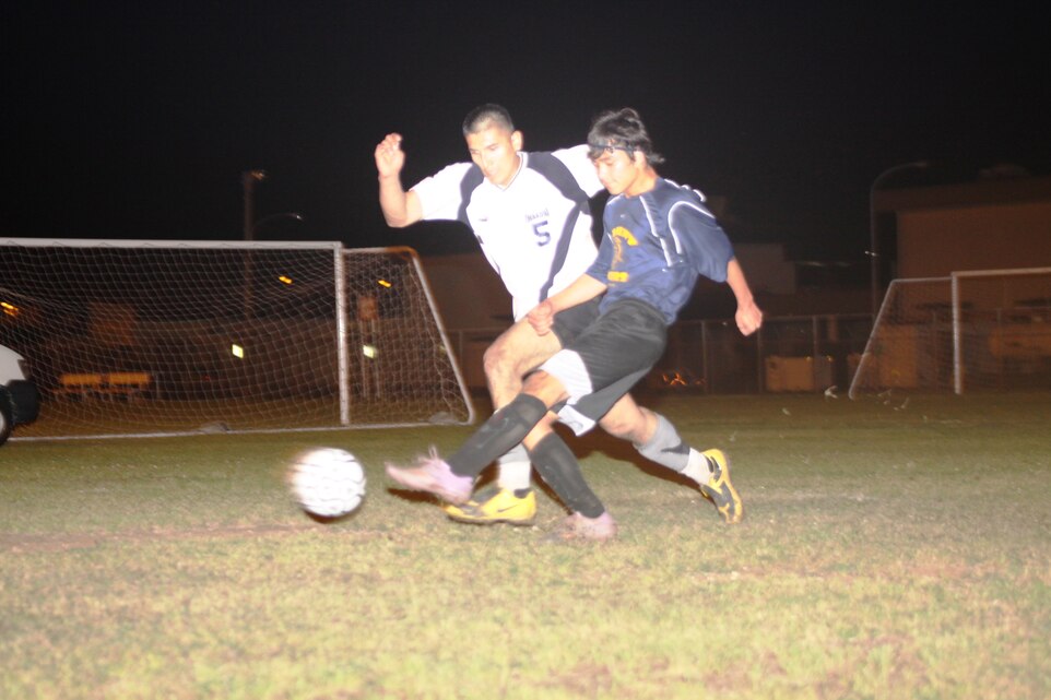Sean Barker, Oriental Tigers forward, lunges in front of a Marine Wing Support Squadron 171 player and attempts to steal the ball during the 6-Man Summer Soccer Tournament championship game at the Penny Lake soccer fields here June 9. This tournament was just a small preview to the upcoming soccer season.