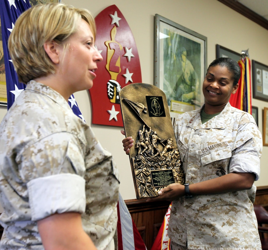 Capt. Stacey Crite, the operations officer for G-1 Manpower, Policy and Plans Division, 2nd Marine Division, presents Maj. Marta D. Sullivan a unit appreciation plaque after Sullivan received the Meritorious Service Medal for exceptional meritorious achievements while serving as the deputy assistant chief of staff for G-1, 2nd MarDiv from Oct. 2010 to March 2011, during an awards ceremony June 9, 2011, aboard Marine Corps Base Camp Lejeune N.C.
