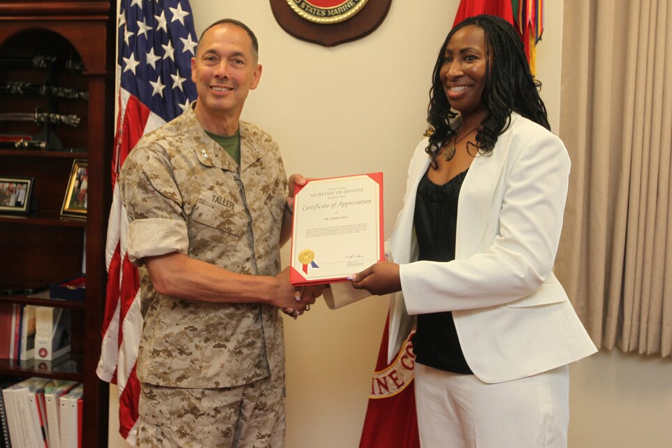 Maj. Gen. Peter J. Talleri , Marine Corps Base Camp Butler commanding general and deputy commander of Marine Corps Bases Japan, presents Melisa J. Price, the identification oversight coordinator for Installation Personnel Administration Center, Headquarters and Service Battalion, Marine Corps Base Camp Butler, with a certificate of appreciation for her hard work and dedication to her job June 10. Price has held the position since January of 2008. Her job is to be responsibility for all identification centers within Marine Corps Bases Japan to include Camps Foster, Hansen, Kinser, Courtney and Marine Corps Air Station Iwakuni.