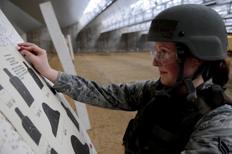 Airman 1st Class Jessica Yeager, 733rd Air Mobility Squadron aircraft service specialist, hangs up a new target at the 18th Security Forces Combat Arms firing range June 1. During the qualification, Airmen go through a zeroing round, a practice round and a timed final round to ensure they are well prepared for upcoming deployments. (U.S. Air Force photo/ Airman 1st Class Maeson L. Elleman)
