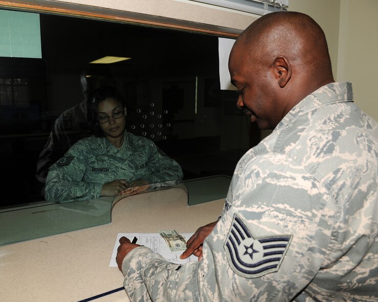 KUNSAN AIR BASE, Republic of Korea -- Tech. Sgt. Steven Jackson, 8th Comptroller Squadron deputy disbursing officer, assists a customer in cashing a check here June 8. The 8th CPTS provides assistance on travel vouchers, pay information and other fianancial services and needs. (U.S. Air Force photo/Senior Airman Ciara Wymbs)