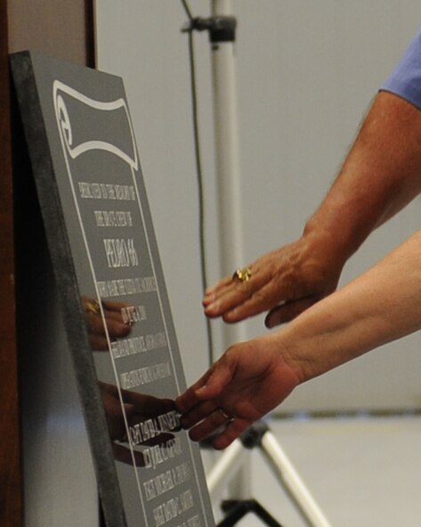 NELLIS AIR FORCE BASE, Nev. -- Mr. Chester Wisniewski and his wife Beverly, parents of fallen HH-60G Pave Hawk helicopter pilot Capt. David A. Wisniewski, touch their son's name on a memorial plaque dedicated to the crew of PEDRO 66.The plaque was revealed during a one year anniversary memorial ceremony honoring the fallen crew members here June 9, 2011. The PEDRO 66 crew's HH-60G Pave Hawk helicopter crashed in Southwest Afghanistan June 9 2010, killing five of the crew and critically injuring two. (U.S. Air Force photo by Staff Sgt. Taylor Worley)(RELEASED)