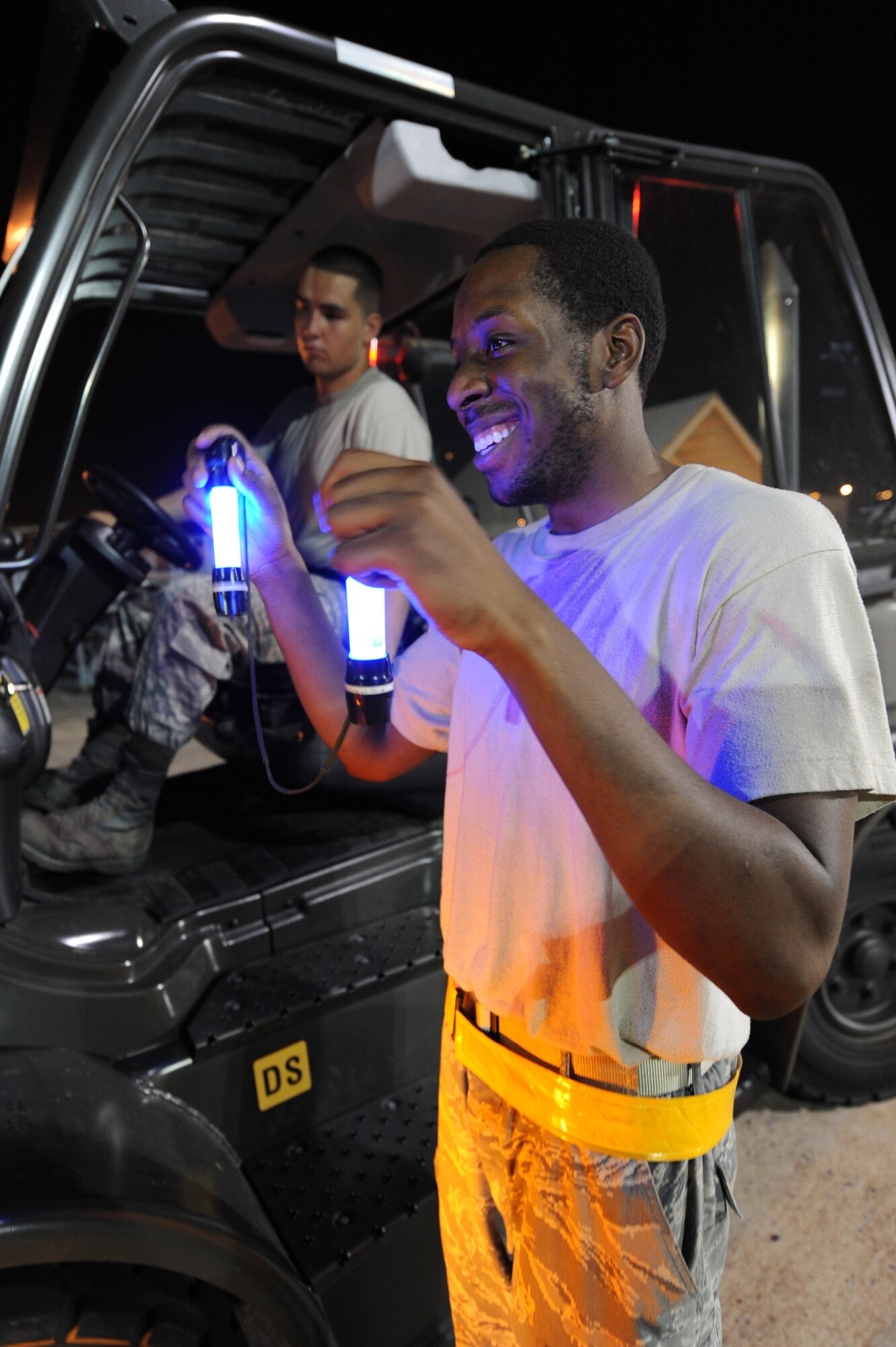 Senior Airman Cornelius Wilkerson (right) gives directions to Senior Airman Adrian Montoya as he drives a forklift June 4, 2011, on Little Rock Air Force Base, Ark.  Airmen Wilkerson and Montoya, both air transportation journeymen with the 19th Logistics Readiness Squadron, supported an operational readiness exercise by loading equipment, storage containers and pallets of baggage onto C-130 aircraft. (U.S. Air Force photo by Tech. Sgt. Chad Chisholm)