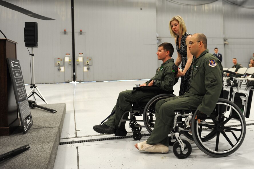 
NELLIS AIR FORCE BASE, Nev. -- Capt. Anthony Simone, his wife Andrea and Master Sgt. Christopher Aguilera look upon the newly- revealed memorial plaque for rescue crew PEDRO 66 after the memorial here June 9, 2011. Captain Simone and Sergeant Aguilera were injured when their HH-60G Pave Hawk helicopter crashed in Southwest Afghanistan June 9, 2010, killing five of their fellow crew members. (U.S. Air Force photo by Staff Sgt. Taylor Worley)(Released)