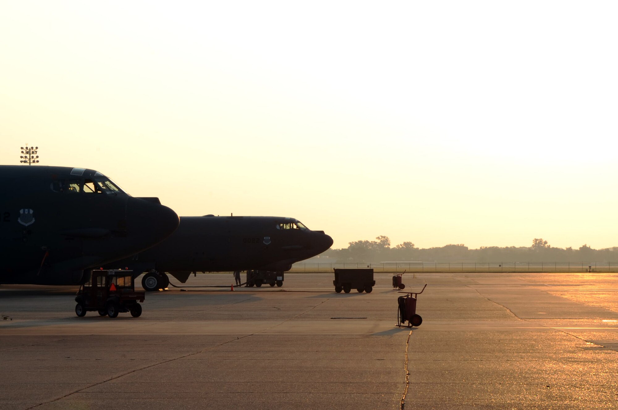 The sun rises over a pair of B-52H Stratofortresses parked on the ramp on Barksdale Air Force Base, La., June 9. The bombers were being readied for the days flying activities. (U.S. Air Force photo/2nd Lt Tori Lalich)