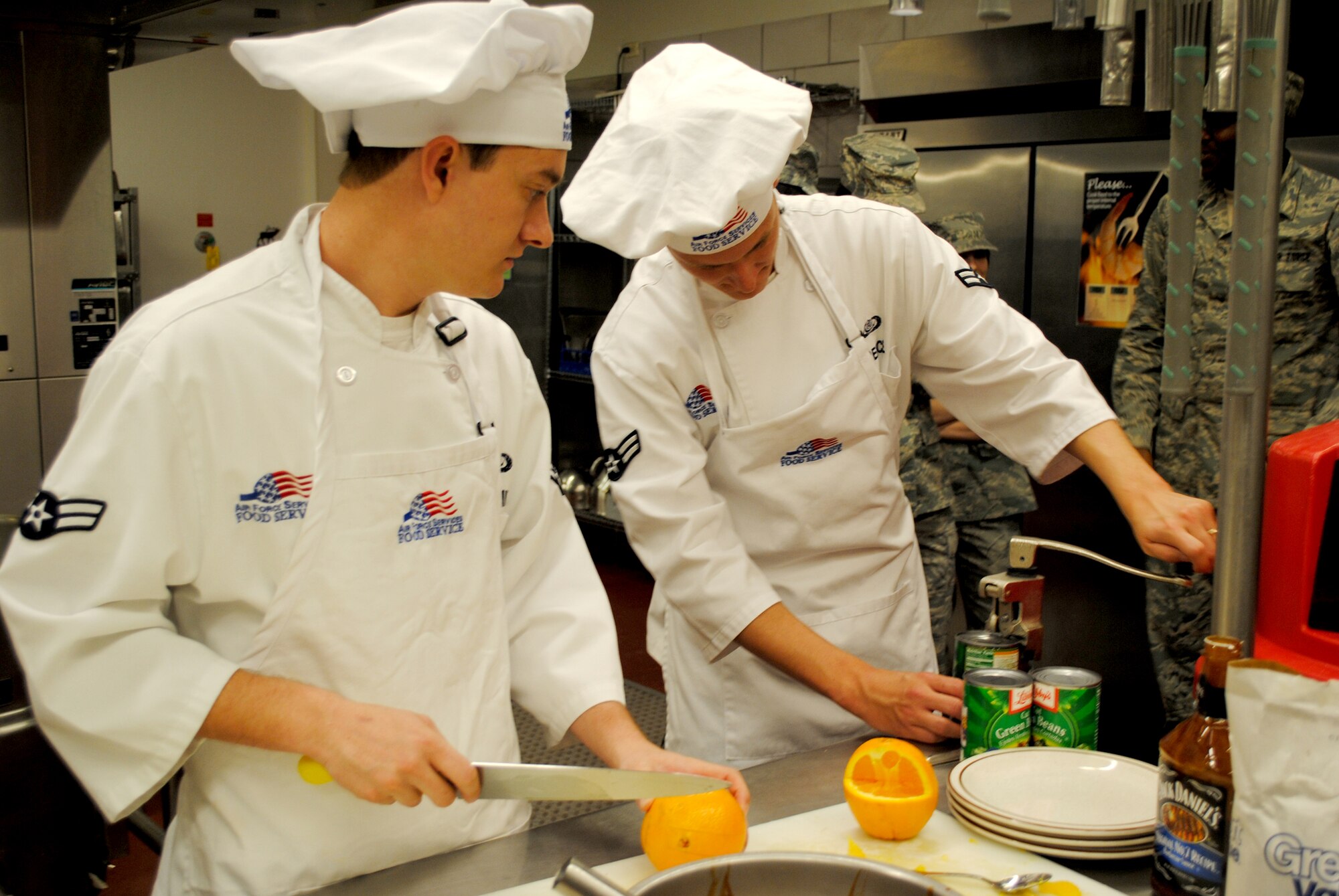 Airmen 1st Class Brenton Schmidt (left) and Paul Breece, both missile chefs with the 490th Missile Squadron, work quickly to prepare their meal for the judges.  Their prepared dish of barbecued chicken legs with green beans topped off with some fried apples was a close second to the winners - only missing the title by one point.  (U.S. Air Force photo/Airman Cortney Hansen)