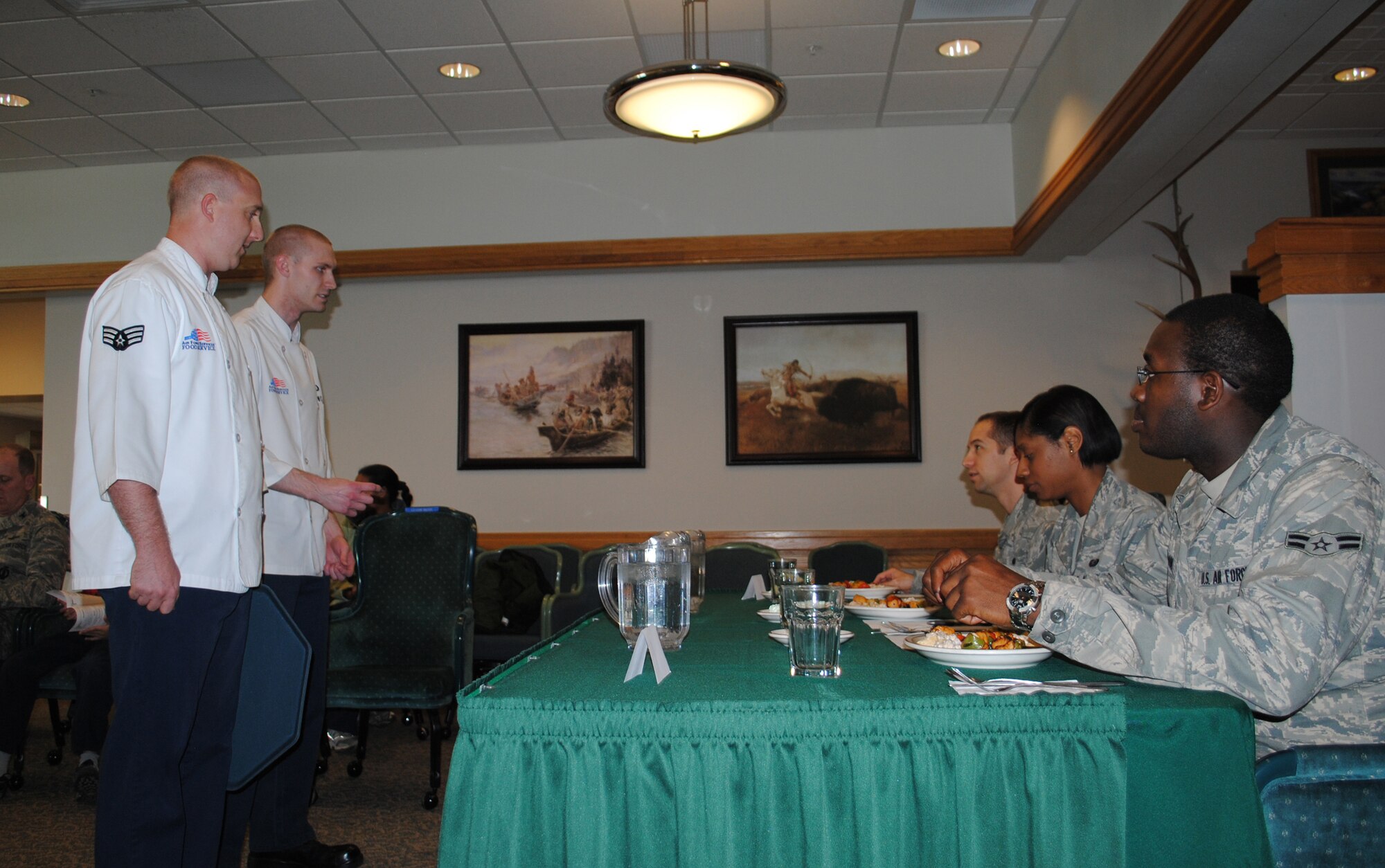 Senior Airman Austin Coleman and Airman 1st Class Blake Ellsworth, missile chefs with the 10th Missile Squadron, deliver Hawaiian kabobs to the judges. The judges were Airman 1st Class Jason Waddy, 490th Missile Squadron missile chef; Senior Airman Dynesha Adams, 341st Force Support Squadron personnelist and Airman 1st Class Andrae Goode, 341st Civil Engineer Squadron visual imagery intrusion detection system technician. (U.S. Air Force photo/Airman 1st Class Katrina Heikkinen)