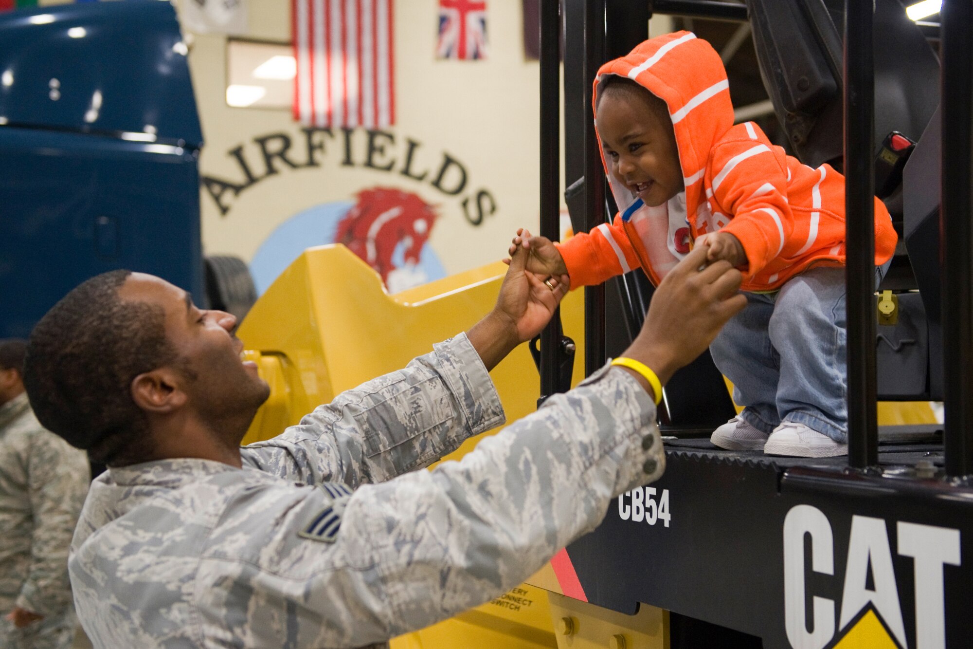 Senior Airman Logan Lindsey, 819th RHS structures specialist, helps his son, Armon, out of the roller during the 819th RHS open house June 3. (U.S. Air Force photo / Beau Wade)