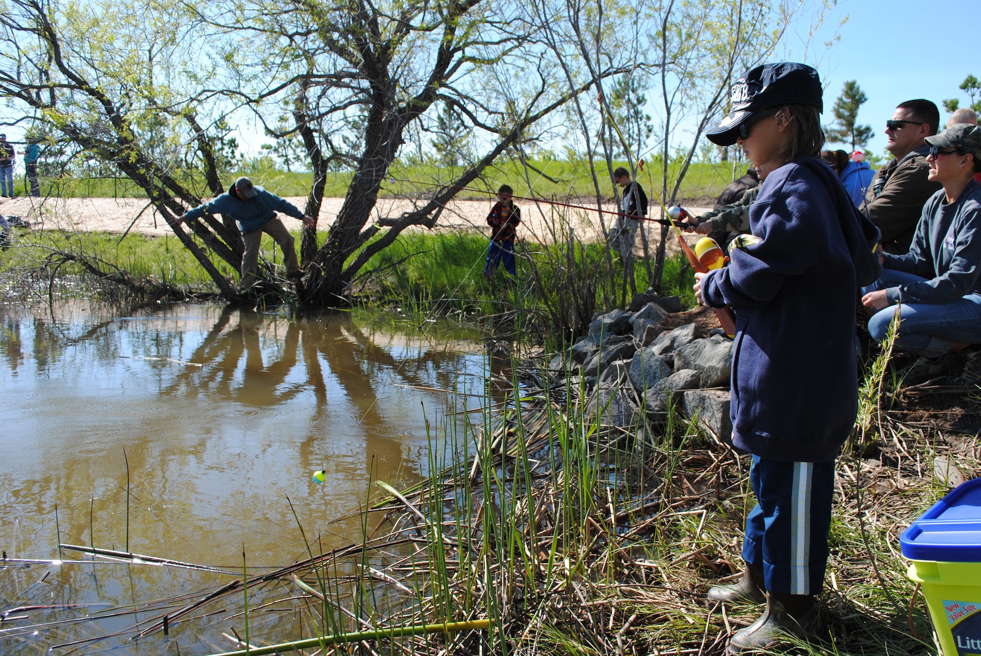 Cristian Reno, 8, waits for a fish to bite while other families enjoy the nice weather around Malmstrom’s Pow Wow Pond. (U.S. Air Force photo/Airman 1st Class Katrina Heikkinen)