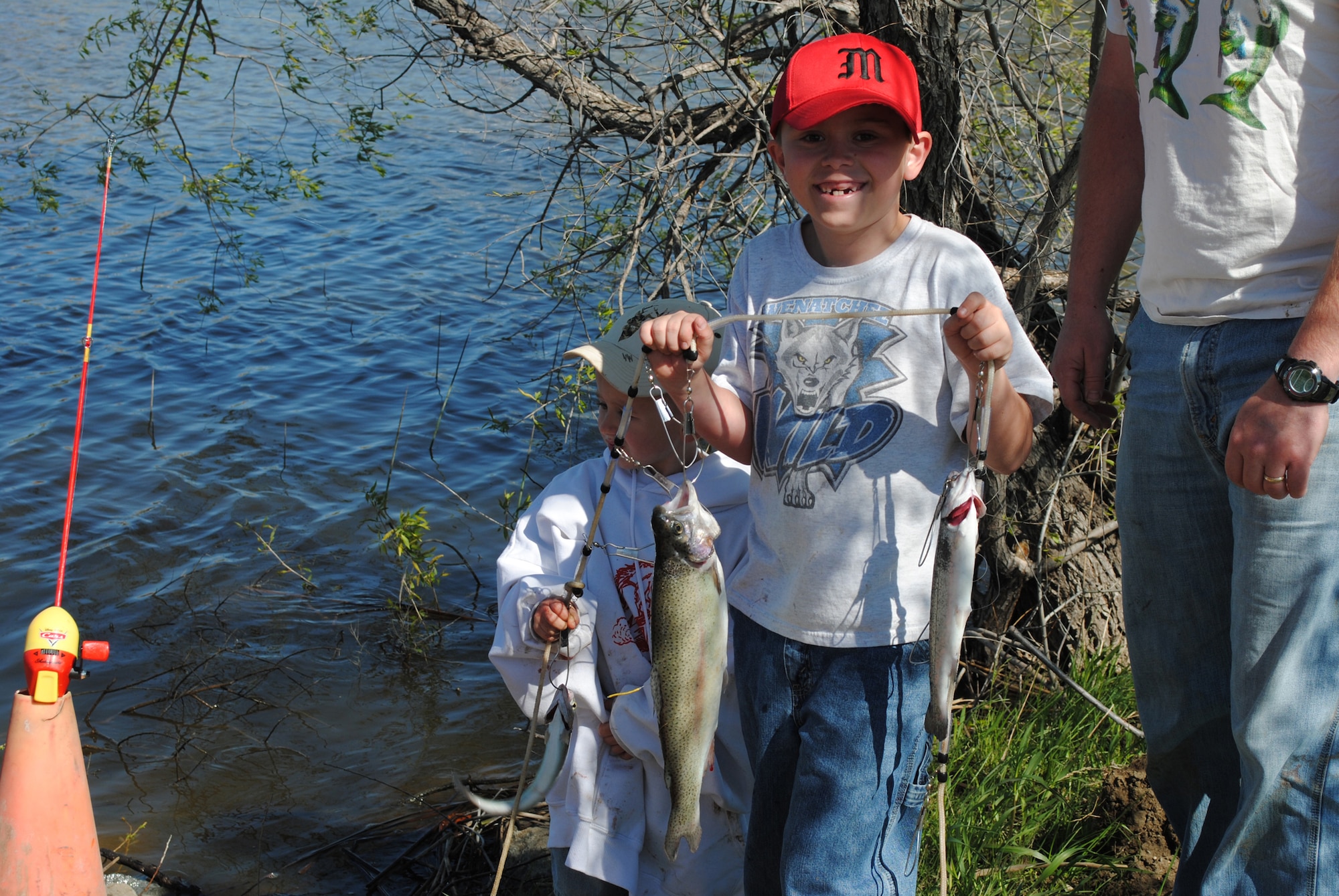 Drake Reathaford, 8, along with help from his brother Levi, 4, (back) proudly shows off the fish they caught at Pow Wow Park on National Kid’s Fishing Day June 4.  (U.S. Air Force photo/Airman 1st Class Katrina Heikkinen)