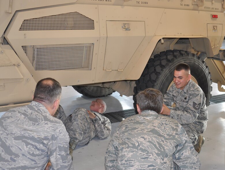 Lt. Gen. Loren M. Reno, Deputy Chief of Staff for Logistics, Installations and Mission Support, Headquarters U.S. Air Force, Washington, D.C. (center, under truck), enjoys a very hands-on look at some of the features of the equipment operated by 610th Security Forces Squadron during a tour of the 301st Fighter Wing and its facilities and resources. TSgt Nicholas Cantu, 610th Security Forces Squadron Ground Combat Skills Instructor, (right) explains the vehicle's unique capabilities to tour participants. (U.S. Air Force Photo/Laura Dermarderosiansmith)