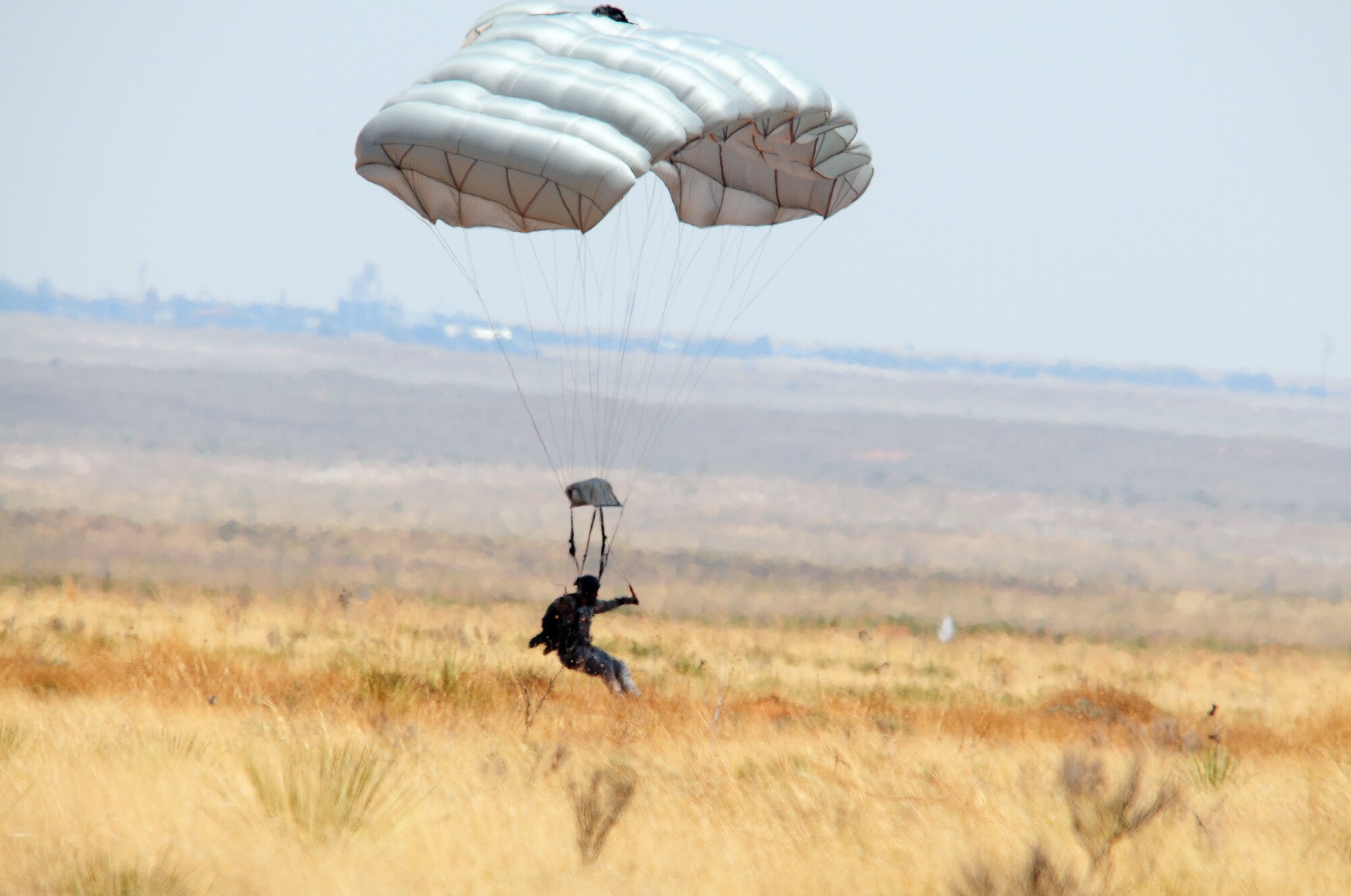 A parachutist simulating an assault team member lands at Melrose Air Force Range during the 27th Special Operations Wing Capabilities Exercise, June 4, 2011. Parachutists were one of many aerial and ground attractions of the CAPEX, which is an annual exhibition of the 27 SOW's many special operations aircraft and missions for Cannon Airmen and their families. (U.S. Air Force photo by Staff Sgt. Nicholas Phelps)(RELEASED)
