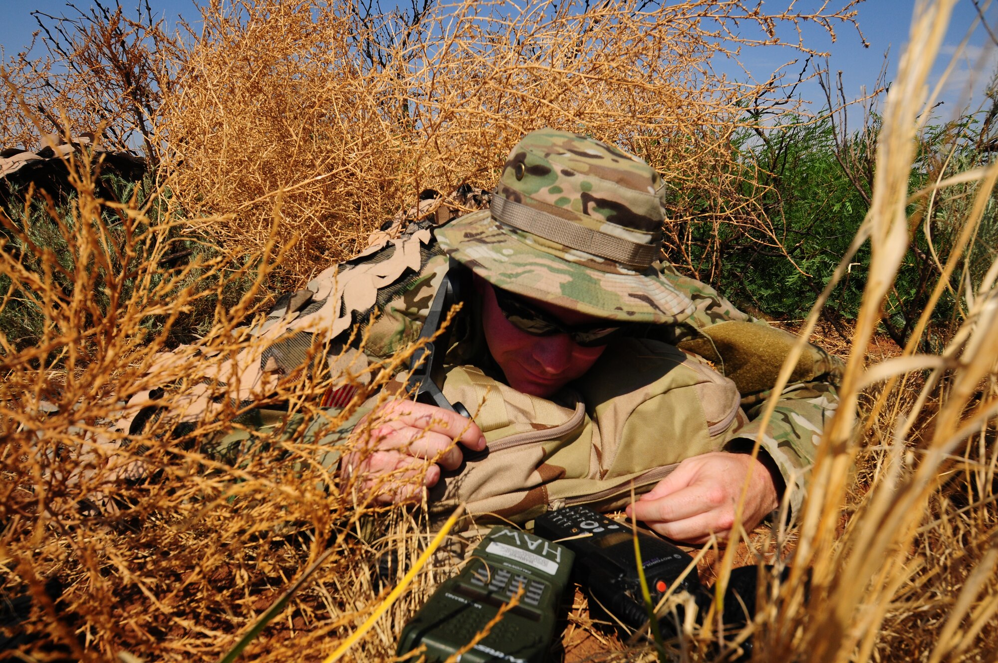 A concealed scenario participant calls in simulated air strikes from the AC-130H Spectre Gunship, playing the role of a Joint Terminal Air Controller as part of an aerial and ground demonstration for around 600 spectators at the 27th Special Operations Wing Capabilities Exercise, June 4, 2011, at Melrose Air Force Range. The CAPEX is an annual exhibition of the 27 SOW's many special operations aircraft and missions for Cannon Airmen and their families. (U.S. Air Force photo by Staff Sgt. Nicholas Phelps)(RELEASED)