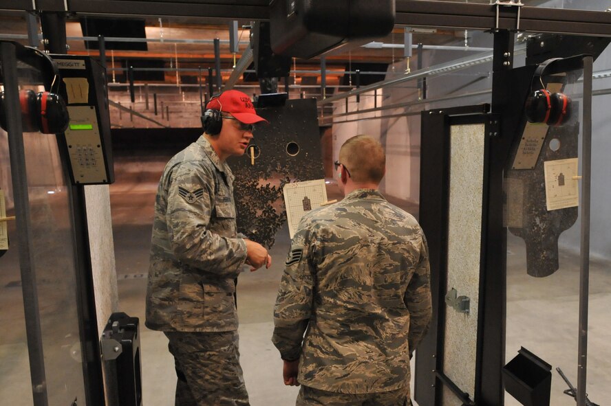SEYMOUR JOHNSON AIR FORCE BASE, N.C.- Senior Airman Daniel Perrotta gives some pointers to Staff Sgt. Jacob Martin about hitting his target during a combat arms training and maintenance course (CATM) here, June 8, 2011. Airman Perrotta is a 4th Security Forces Squadron CATM instructor and a native of Decatur, Ga. Sergeant Martin is a 4th Operations Group target analyst and a native of Buffalo, N.Y. (U.S. Air Force photo/Senior Airman Whitney Lambert)(RELEASED)