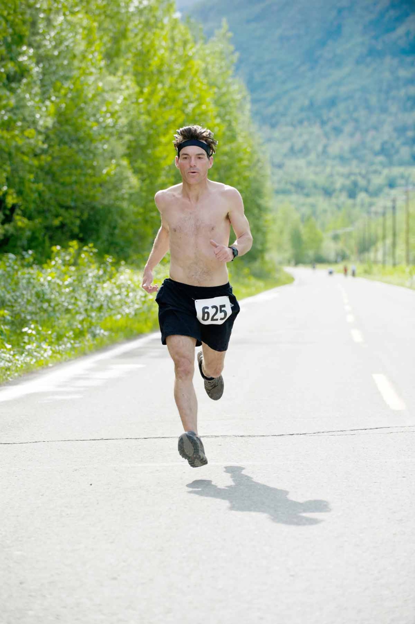 Timothy Blake crosses the finish line of the 12.5-mile run, with a time of 1:30:49. Second place went to David Driscoll of Headquarters and Headquarters Company, 725th Brigade Support Battalion, with Susan Casey and Ann Williams placing third and fourth.  (U.S. Air Force photos\Johnathon Green)