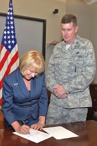 Dr. Linda Shifflette, Hampton City Schools superintendent, and Col. Donald Kirkland, 633d Air Base Wing commander, sign an agreement with the school district at Langley Air Force Base, Va., June 7, 2011. Langley AFB will provide approximately 20 unit mentors and tutors to more than 30 Hampton City schools. (U.S Air Force photo by Airman 1st Class Camilla Griffin/Released)