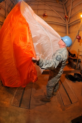 Master Sgt. Jerry Payne, 336th Training Support Squadron aircrew flight equipment superintendent, completes a " shake out" procedure on a C-9 canopy parachute after a jump mission May 13, 2011, at Fairchild Air Force Base, Wash. The purpose of this procedure is to remove FOD or debris that could initially cause tears or malfuntions to a parachute after it's repacked from the field. (U.S Air Force Photo/Tech Sgt. J.T. May III) 