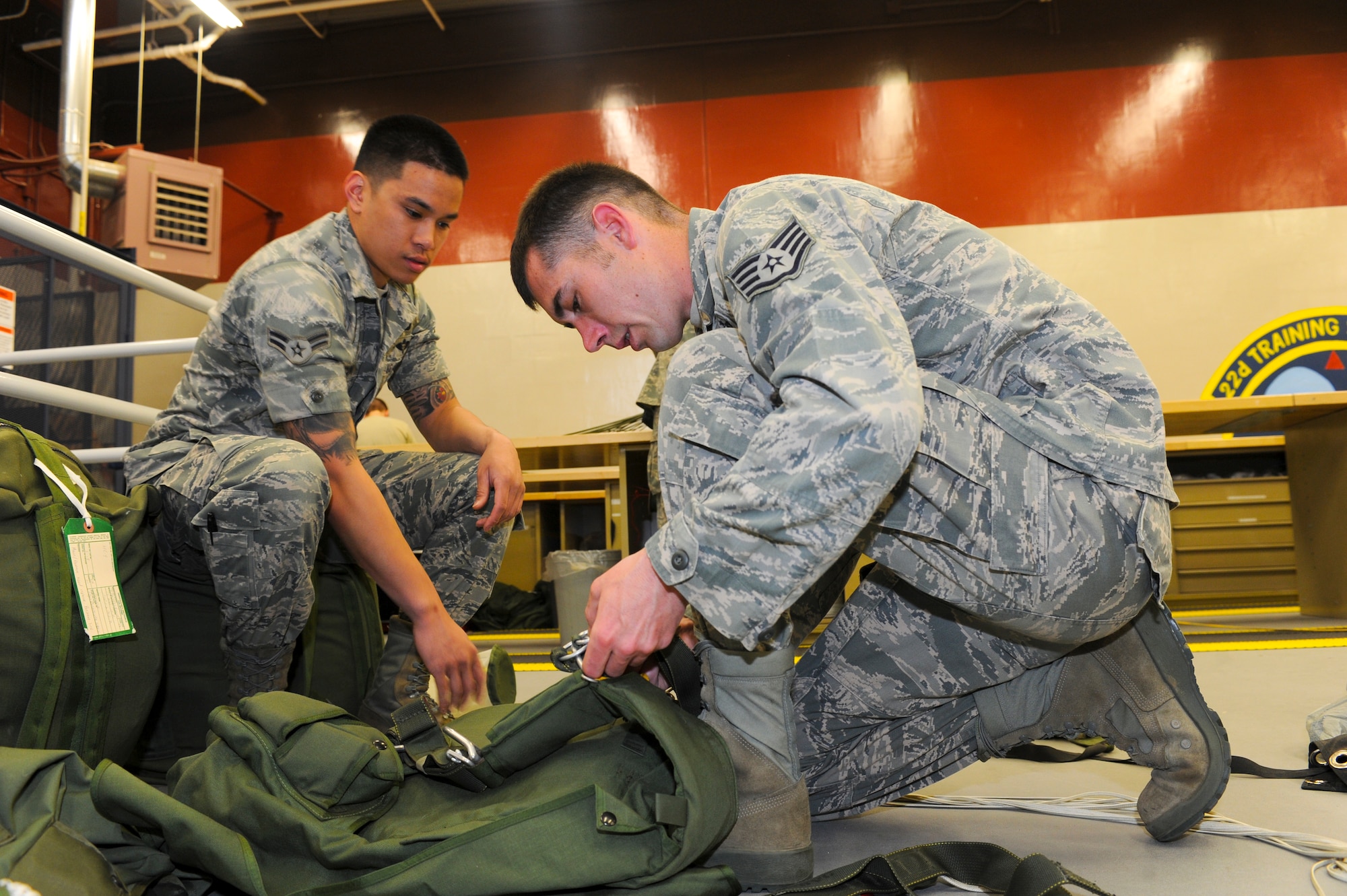 Airman 1st Class Alexander Mercado, 336th Training Support Squadron, aircrew flight equipment specialist add Staff Sgt. Michael Brown, 336 TRSS, NCO in charge aircrew flight equipment, install a new canopy on the MC-4 Free Fall parachute system May 13, 2011 at Fairchild AFB, Wash. (U.S. Air Force Photo/Tech Sgt. JT May III)