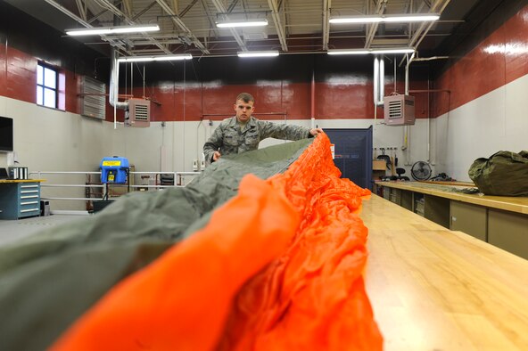 Airman 1st Class Shane Bedard, 336th Training Support Squadron, aircrew flight equipment specialist, conducts an inspection on a C-9 canopy parachute May 13, 2011, at Fairchild Air Force Base, Wash. Parachute riggers perform a critical job by rigging and maintaining all parachutes. (U.S. Air Force Photo/Tech. Sgt. J.T. May III)