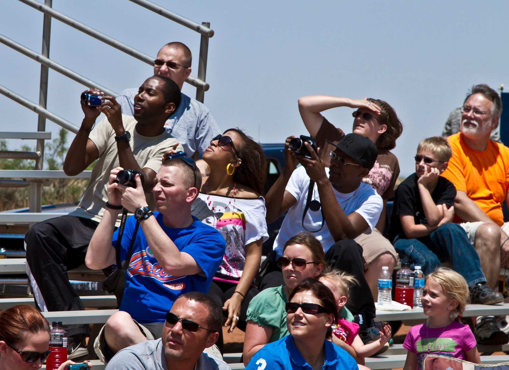 Spectators watch and photograph an aerial demonstration as part of the 27th Special Operations Wing Capabilites Exercise, June 4, 2011 at Melrose Air Force Range.  The CAPEX is an annual exhibition of the 27 SOW's many special operations aircraft and missions for Cannon Airmen and their families.  (U.S. Air Force photo by 2nd Lt. Stephanie Strine)(RELEASED)