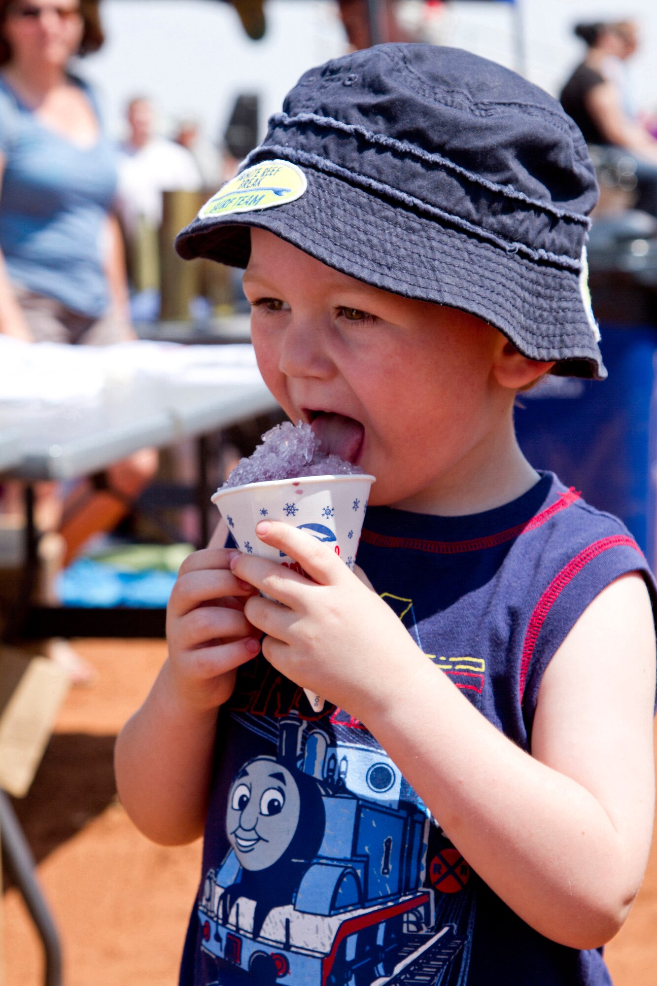 A child enjoys a grape-flavored snow cone at the 27th Special Operations Wing Capabilities Exercise at Melrose Air Force Range, June 4, 2011.  The CAPEX is an annual exhibition of the 27 SOW's many special operations aircraft and missions for Cannon Airmen and their families.  (U.S. Air Force photo by 2nd Lt. Stephanie Strine)(RELEASED)