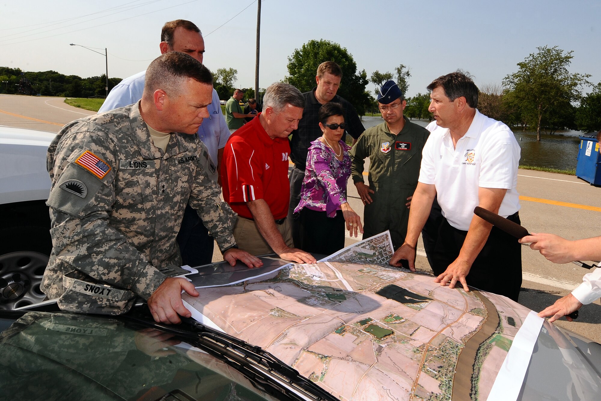 OFFUTT AIR FORCE BASE, Neb. - Army Corp of Engineers Maj. Gen. Judd Lyons, Governor Dave Heineman, Bellevue Mayor Rita Sanders, 55th Wing commander Brig. Gen. Donald Bacon and other officials look over a satellite map of the Missouri river and the corresponding metropolitan areas that could see heavy damages if the levee's were to fail at Hayworth Park in Bellevue. Preparation for the increased water levels from the Missouri River is crucial in how Offutt adapts to continuing its mission despite the record water flow.  U.S. Air Force Photo by Josh Plueger.