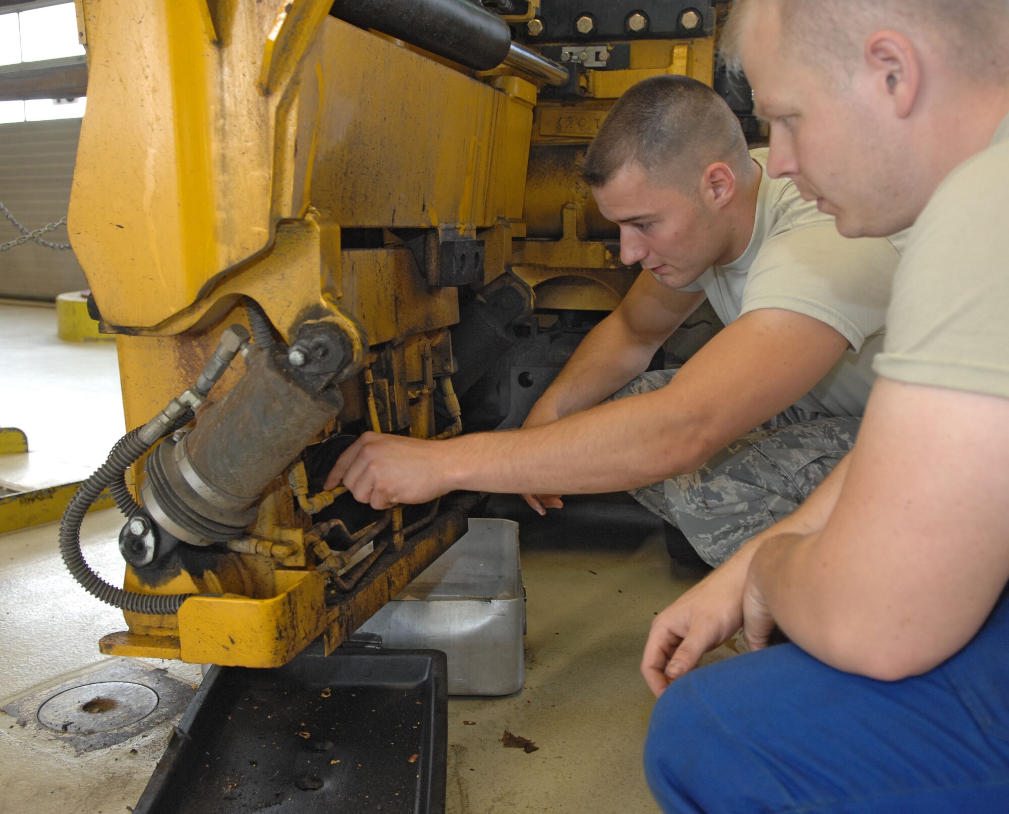 SPANGDAHLEM AIR BASE, Germany – Senior Airman John Stark, left, 52nd Logistics Readiness Squadron vehicle maintenance journeyman, works under the supervision of Staff Sgt. Robert McCampbell, 52nd LRS vehicle maintenance journeyman, here June 8. The vehicle maintenance flight fixes and inspects heavy equipment in need of maintenance and repair. (U.S. Air Force photo/Airman 1st Class Matthew B. Fredericks)