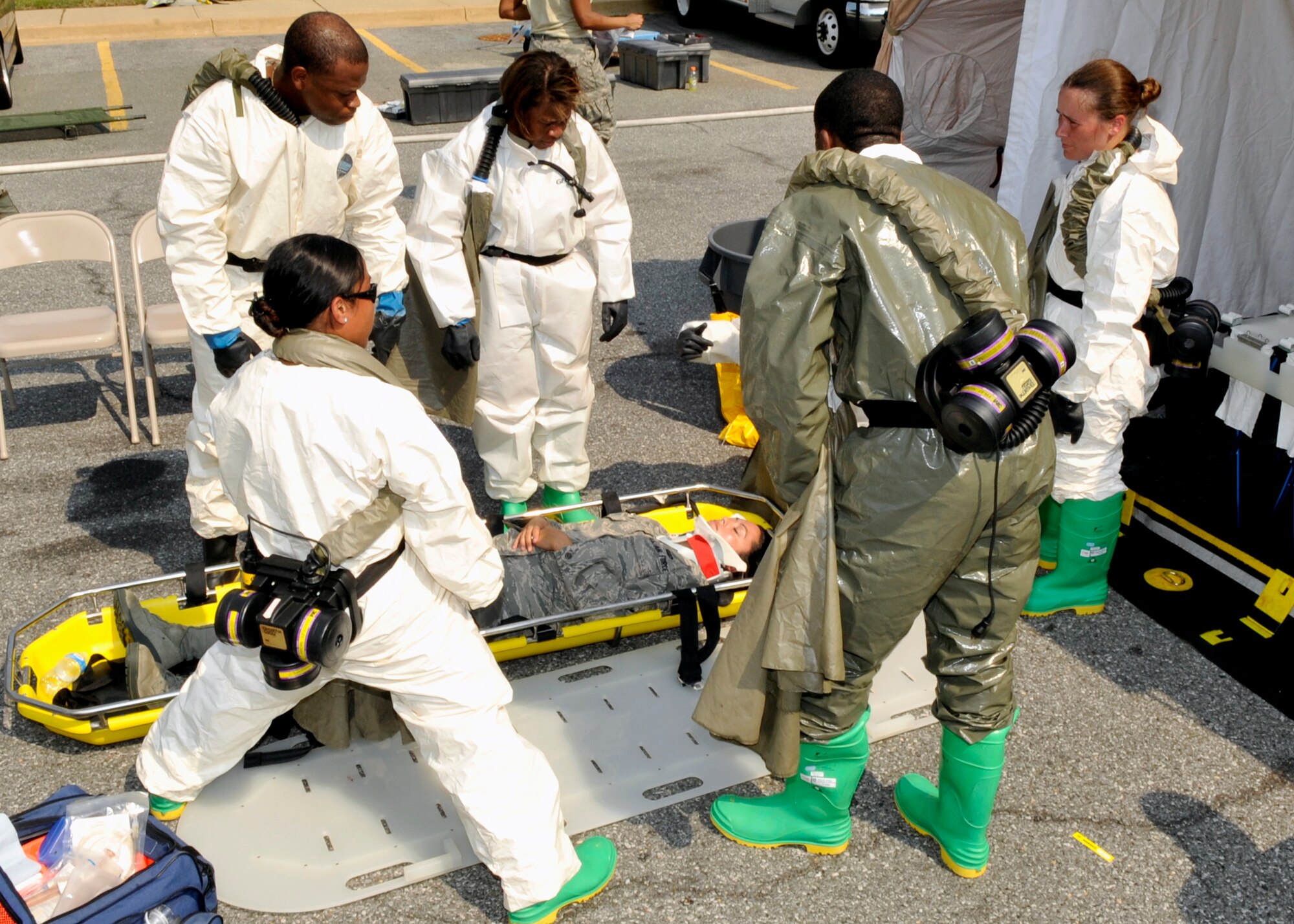 Members of the 779th Medical Group prepare to lift a patient into the decontamination tent during an exercise Thursday, June 9. Frequent training ensures the medical professionals are capable of moving people efficiently through the decontamination tent in the event of industrial, accidental, or intentional contamination by hazardous materials. (U.S. Air Force photo/Senior Airman Laura Turner)