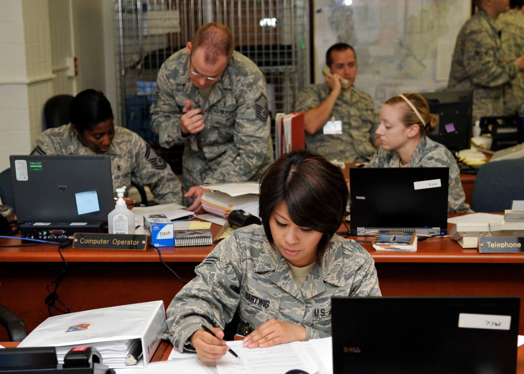 Senior Airman Benna Hartwig, 779th Medical Support Squadron, and other members of the 779th Medical Group stay busy managing phone calls, pages, and e-mail traffic in the Medical Control Center during an exercise Thursday, June 9. The exercise took place as part of the Unit Compliance Inspection at Joint Base Andrews. (U.S. Air Force photo/Senior Airman Laura Turner)