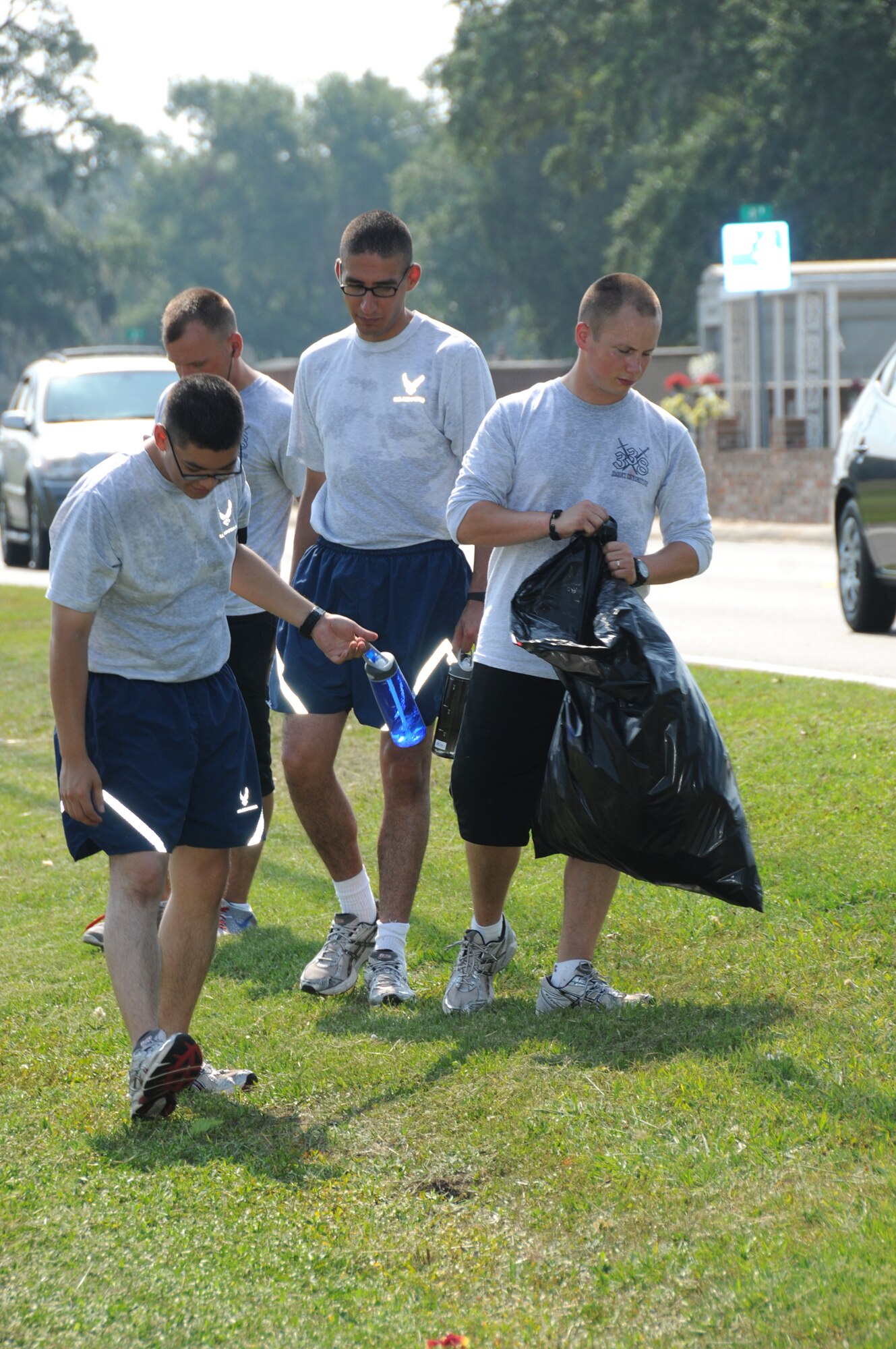 From left, Airman Basic William Seagle,Airman 1st Class Christopher Erdt, Airman Allen Santiago and Airman 1st Class Aaron Ross, students in the 338th Training Squadron, pick up trash along Irish Hill Drive outside the White Avenue Gate, June 2. The Dark Knights have adopted the area as a community service project.  (U.S. Air Force photo by Kemberly Groue)