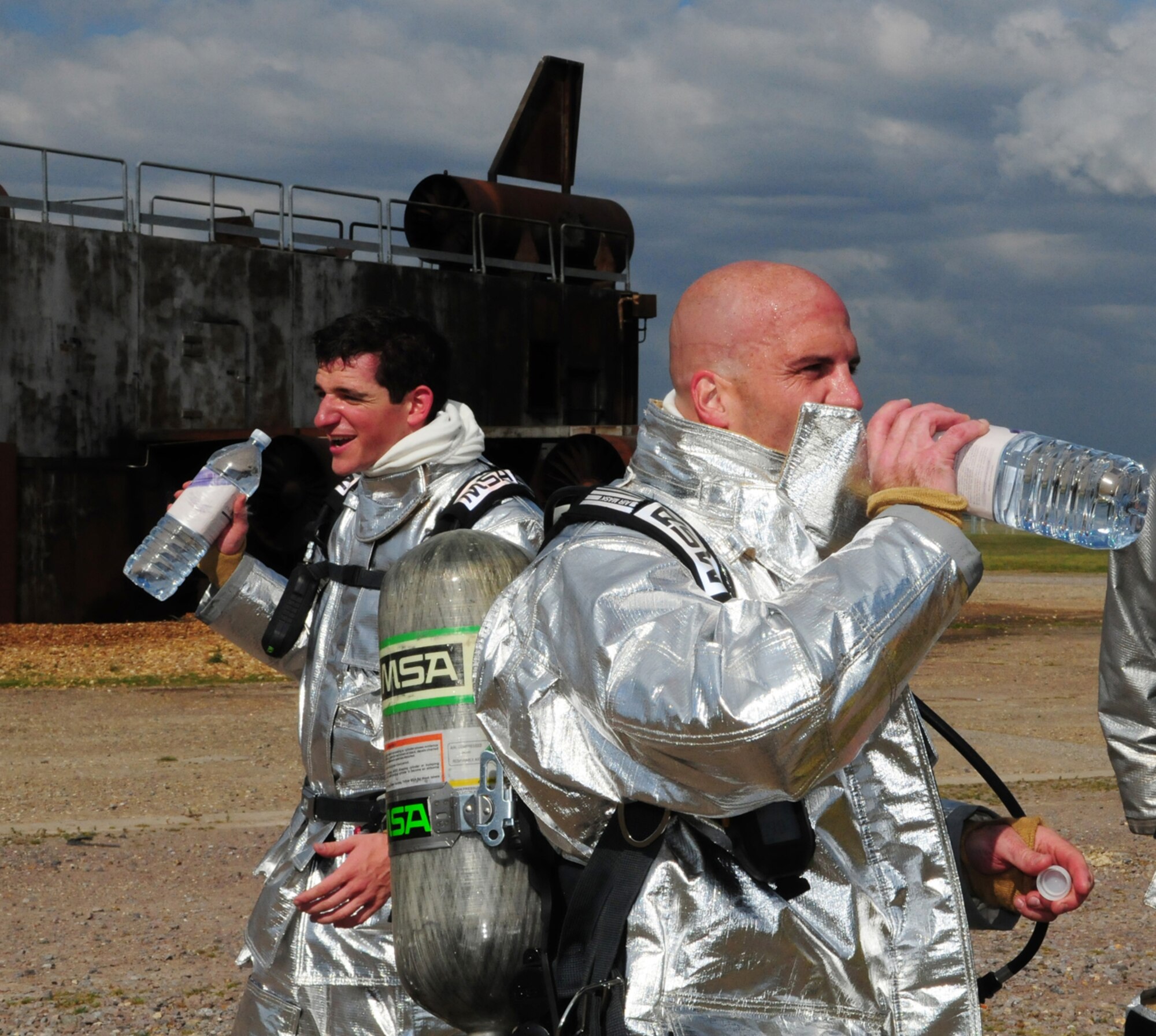 RAF MILDENHALL, England -- Col. Chad Manske, right, 100th Air Refueling Wing commander, and Cadet 2nd Class Craig Nowadly, from the U.S. Air Force Academy, Colo., take a break after fighting fire at the live-fire trainer June 7, 2011. They took turns going in to the fire training house, which was filled with smoke and in complete darkness, each with a firefighter from the 100th Civil Engineer Squadron Fire Department. While inside, they had to locate a mannequin and bring it outside. (U.S. Air Force photo/Karen Abeyasekere)