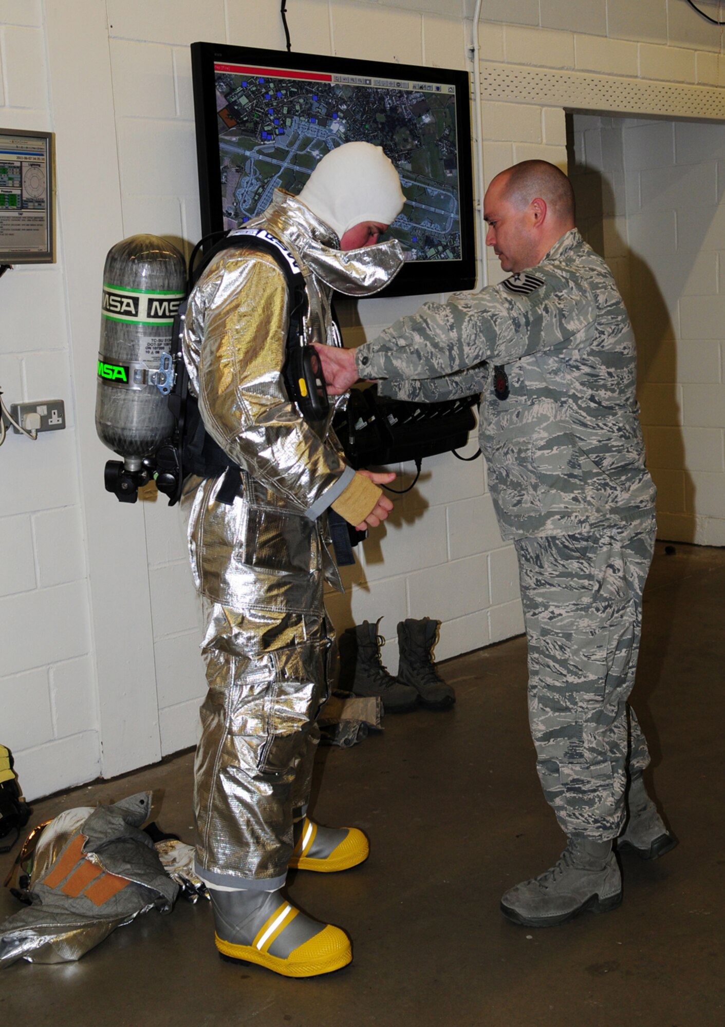 RAF MILDENHALL, England -- A 100th Civil Engineer Squadron Fire Department firefighter, right, helps Cadet 2nd Class Craig Nowadly, from the U.S. Air Force Academy, Colo., properly put on protective gear June 7, 2011. The cadet, along with Col. Chad Manske, 100th Air Refueling Wing commander, had the opportunity to perform live-fire training with the firefighters. (U.S. Air Force photo/Karen Abeyasekere)