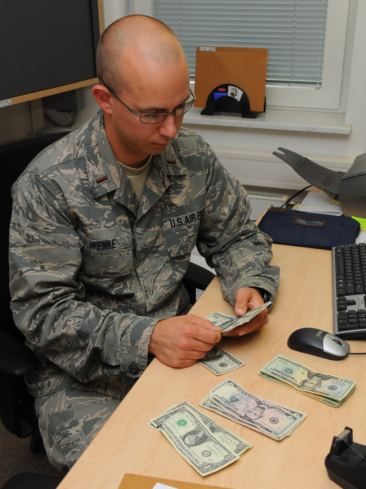 SPANGDAHLEM AIR BASE, Germany – Second Lt. Adam Wenke, 52nd Comptroller Squadron deputy disbursing officer, counts money inside the cashier cage here June 9. The cashier cage services the base’s Airmen and families by funding vouchers, loans and other financial needs for the Spangdahlem Air Base community. (U.S. Air Force photo/Airman 1st Class Dillon Davis)