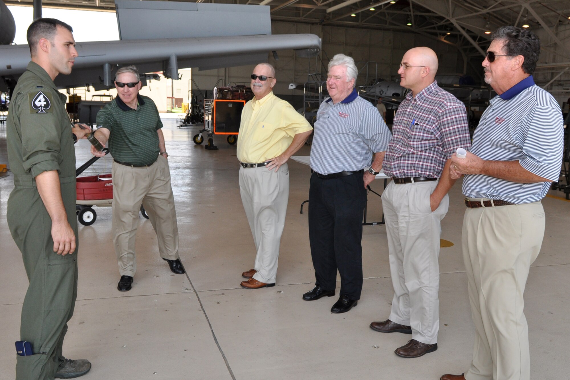 Brig. Gen. (Ret) Jack Ihle, a former commander of the 917th Wing, hands a dummy 30mm round back to 1st Lt. Gant Petty, A-10 pilot, 47th Fighter Squadron, during a visit in the A-10 Hangar at Barksdale Air Force Base, La., by the founders of Texas Wounded Warrior, May 24, 2011. From right to left are Harley Wilke, one of the founders of Texas Wounded Warrior, Thomas P. Gros, board member, Dick Goetz, chairman, TWW, Ron Nash, vice-chair, TWW, General Ihle and Lieutenant Petty. Texas Wounded Warrior, an organization founded by golfers, makes it part of its mission to honor, and to empower our Wounded Warriors by providing them a weekend of fun, fellowship and entertainment on the golf course. (U.S. Air Force photo/Tech. Sgt. Jeff Walston) 