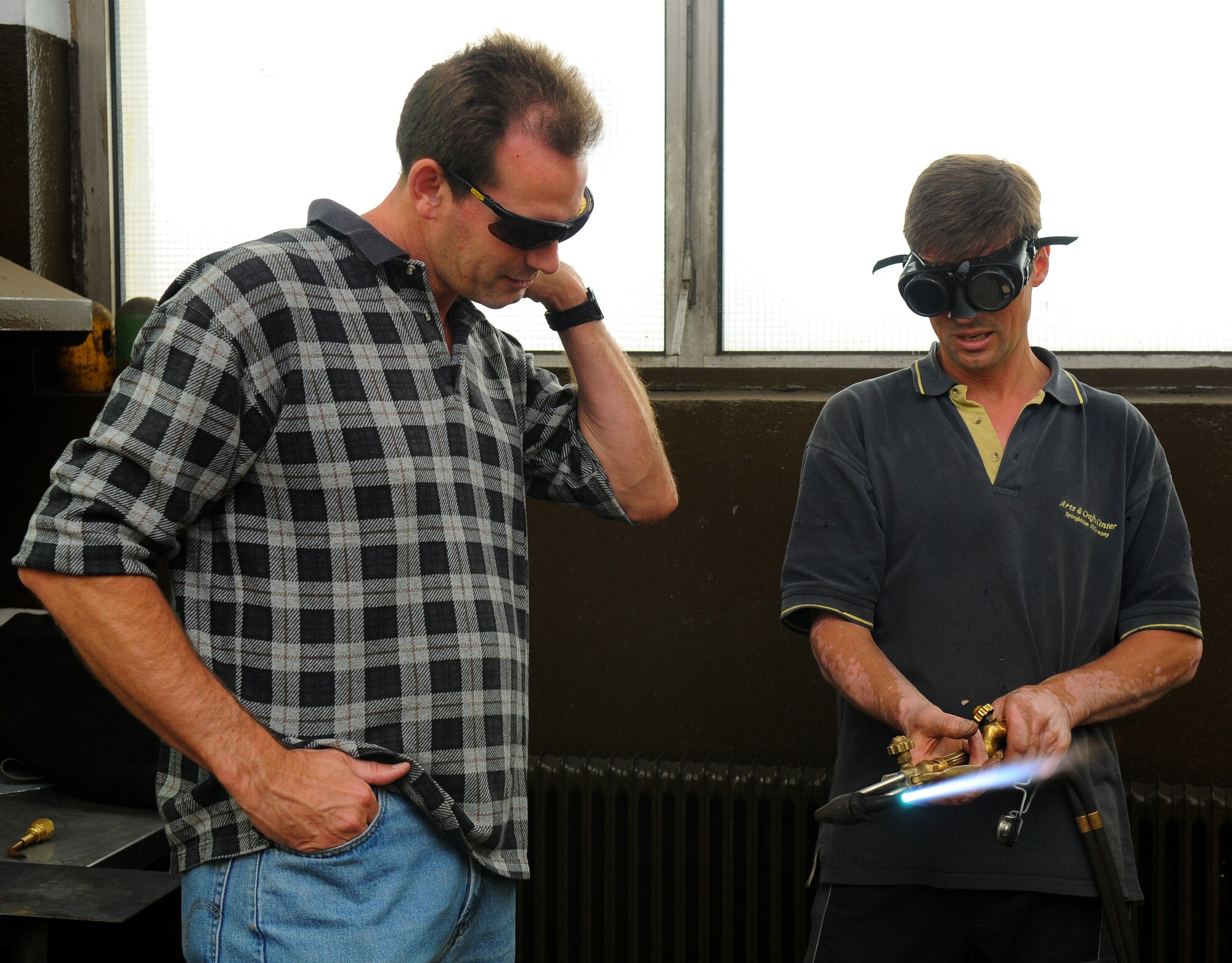 SPANGDAHLEM AIR BASE, Germany – Scott Livingston, left, U.S. Army Garrison Kaiserslautern Safety Team civilian contractor, learns how to adjust the welding tip temperature from welding class instructor Max Baer, 52nd Force Support Squadron civilian contractor, at the auto skills center here June 8. Welding classes are offered monthly at Spangdahlem’s auto skills center. (U.S. Air Force photo/Airman 1st Class Dillon Davis)