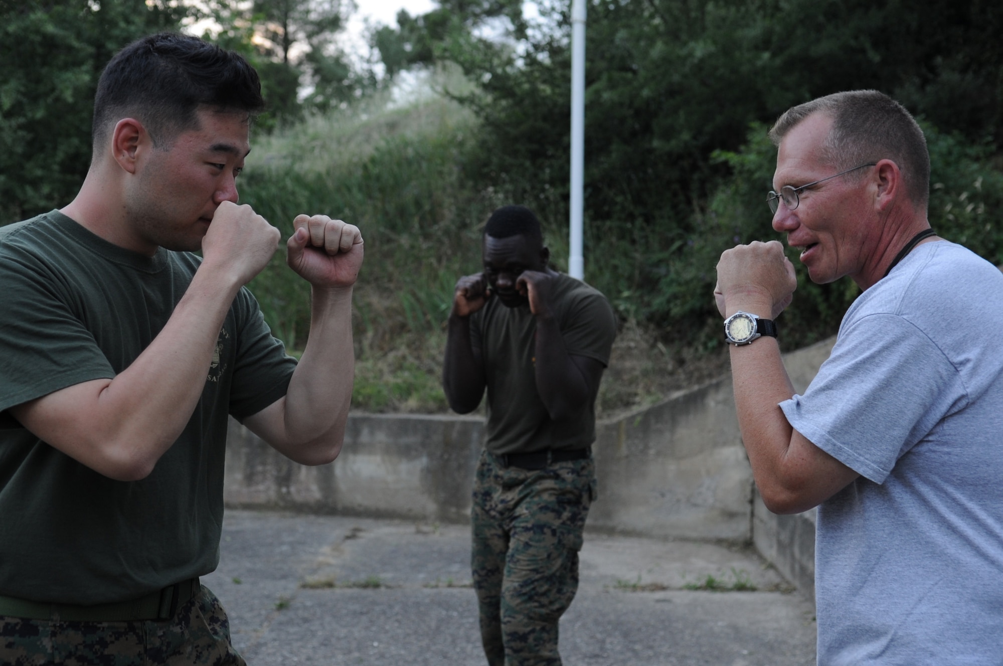 CAMP PEPELISHTE, Macedonia ? Left, U.S. Marine Cpl. Eric Ahn, 4th Marine Logistics Group personnel and retrieval processing specialist, from Anacostia, Washington D.C., demonstrates the basic warrior stance to Chief Master Sgt. Joshua Mills(right), 3rd Air Force Surgeon General?s Office chief, U.S. Air Forces in Europe medical logistics functional manager and senior Air Force enlisted advisor for Medical Training Exercise in Central and Eastern Europe 2011, during a Marine Corps Martial Arts Program demonstration as Marine Staff Sgt. Tresor Mbunker, 4 MLG , PRP company mortuary affairs staff non-commissioned officer in charge, and a black belt MCMAP instructor from Smyrna, Ga., looks on June 8. The U.S. Air Force, Army and Marines are participating in MEDCEUR 11. An annual Chairman of the Joint Chiefs of Staff-sponsored regional and multilateral exercise, MEDCEUR 2011 is designed to provide medical training and operational experience in a deployed environment for U.S. and partner nations. The countries participating in this year?s MEDCEUR are Macedonia, Montenegro, Bosnia and Herzegovina, Serbia, Slovenia and Norway.  The exercise will include both classroom and hands-on training and run until June 15. (U.S. Air Force photo/Staff Sgt. Nadine Y. Barclay)