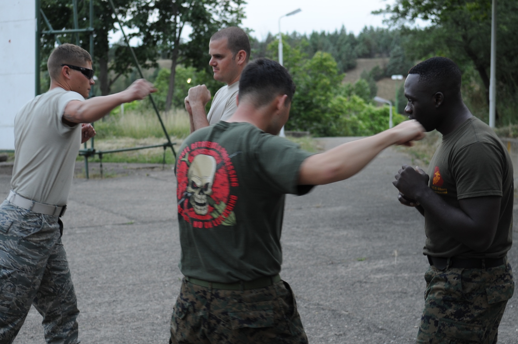 CAMP PEPELISHTE, Macedonia ? Left, U.S. Marine Cpl. Eric Ahn, 4th Marine Logistics Group personnel and retrieval processing specialist, from Anacostia, Washington D.C., demonstrates the basic warrior stance to Chief Master Sgt. Joshua Mills(right), 3rd Air Force Surgeon General?s Office chief, U.S. Air Forces in Europe medical logistics functional manager and senior Air Force enlisted advisor for Medical Training Exercise in Central and Eastern Europe 2011, during a Marine Corps Martial Arts Program demonstration as Marine Staff Sgt. Tresor Mbunker, 4 MLG , PRP company mortuary affairs staff non-commissioned officer in charge, and a black belt MCMAP instructor from Smyrna, Ga., looks on June 8. The U.S. Air Force, Army and Marines are participating in MEDCEUR 11. An annual Chairman of the Joint Chiefs of Staff-sponsored regional and multilateral exercise, MEDCEUR 2011 is designed to provide medical training and operational experience in a deployed environment for U.S. and partner nations. The countries participating in this year?s MEDCEUR are Macedonia, Montenegro, Bosnia and Herzegovina, Serbia, Slovenia and Norway.  The exercise will include both classroom and hands-on training and run until June 15. (U.S. Air Force photo/Staff Sgt. Nadine Y. Barclay)