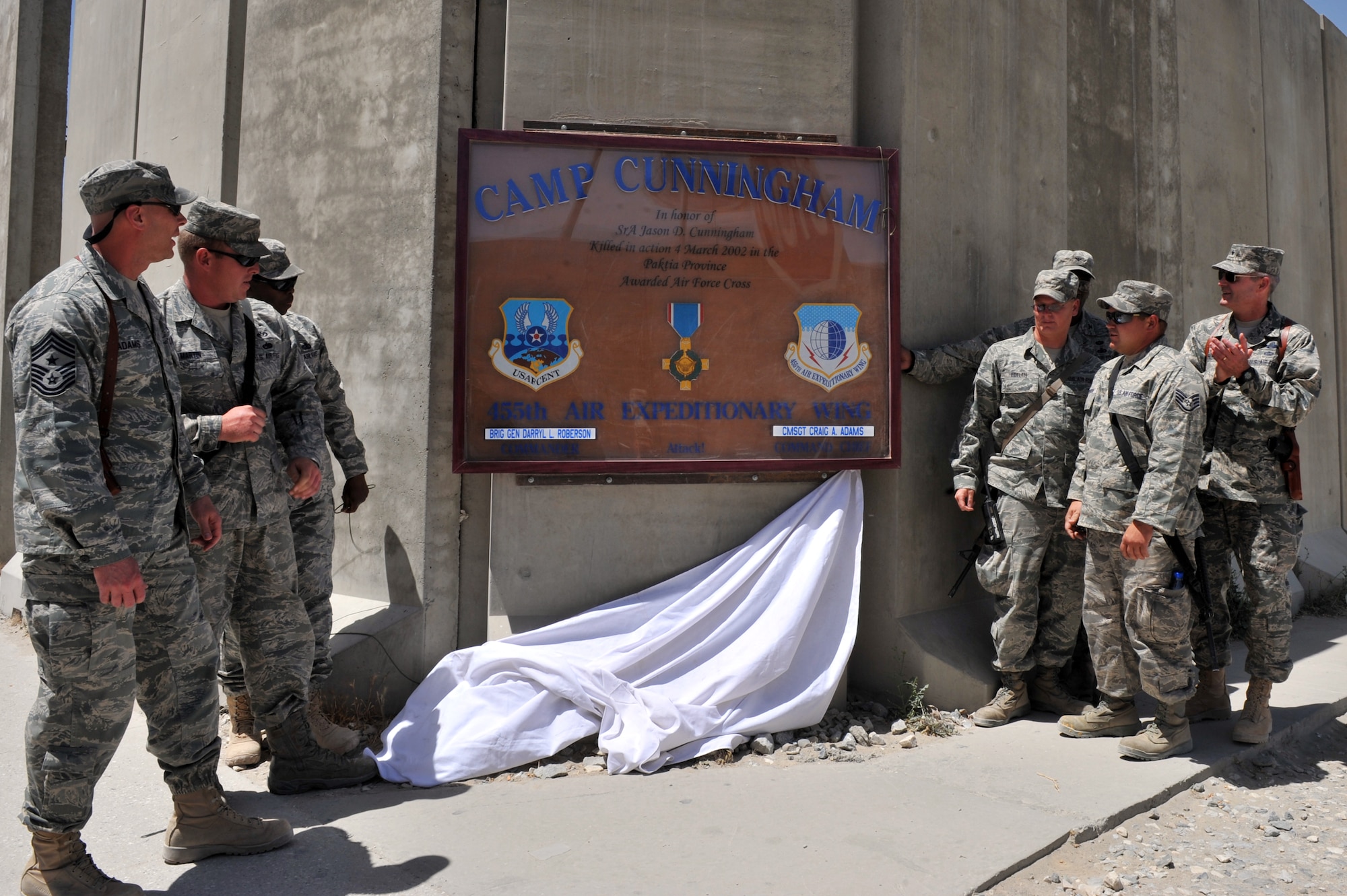 Wing leadership and Airmen from the 455th Air Expeditionary Wing unveil a newly restored Camp Cunningham sign  at Bagram Airfield, Afghanistan, June 9, 2011. Camp Cunningham was named in honor of Senior Airman Jason Cunningham who was killed in action March 2, 2002. (U.S. Air Force photo by Senior Airman Sheila deVera)