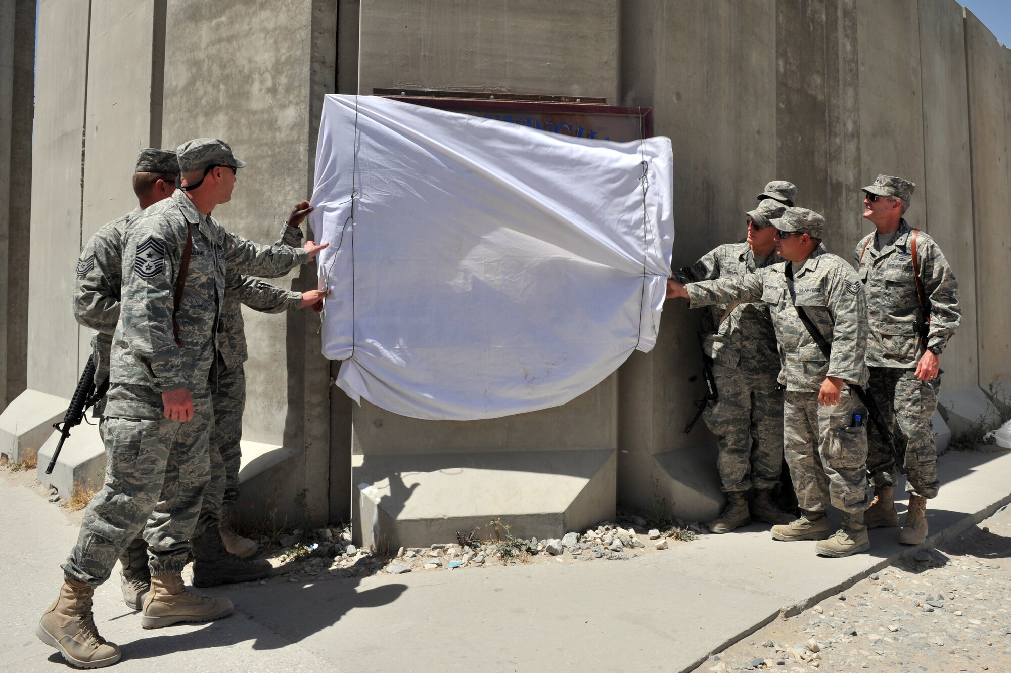 Wing leadership and Airmen from the 455th Air Expeditionary Wing unveil a newly restored Camp Cunningham sign  at Bagram Airfield, Afghanistan, June 9, 2011. Camp Cunningham was named in honor of Senior Airman Jason Cunningham who was killed in action March 2, 2002. (U.S. Air Force photo by Senior Airman Sheila deVera)
