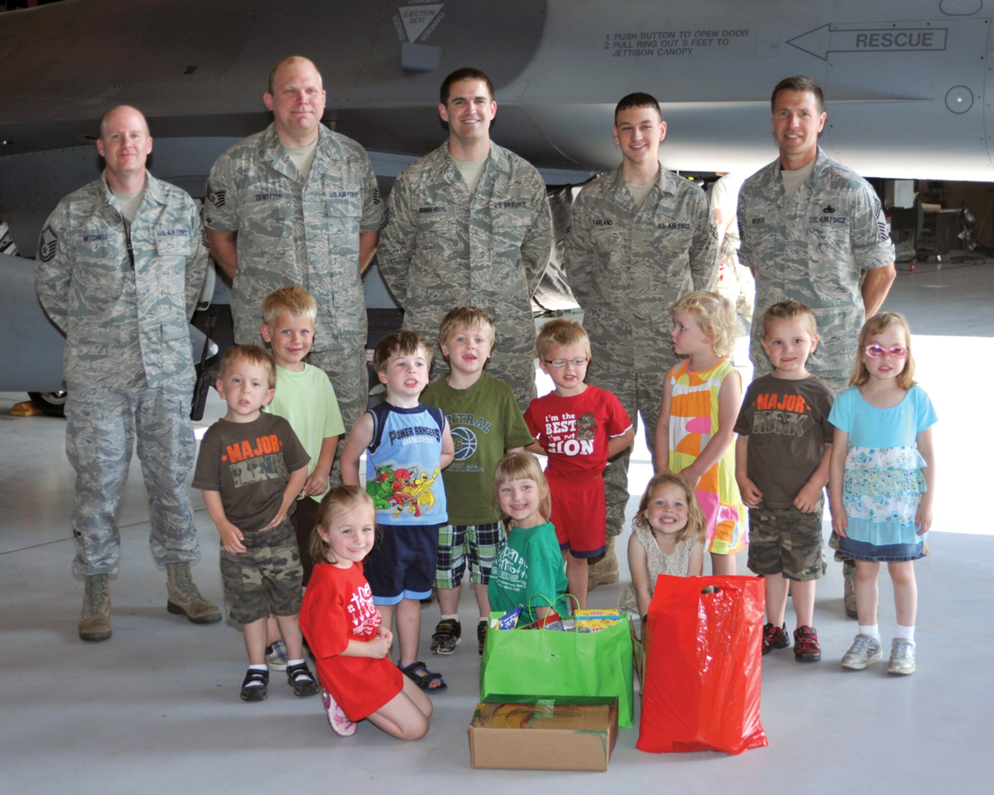 Members of the South Dakota Air National Guard are photographed with children from the Open Arms Christian Child Care Center at Joe Foss Field June 7.  The children visited the base to distribute care package they put together for the deployed members of the unit.  (Air Force photo by Master Sgt. Nancy Ausland)(RELEASED)