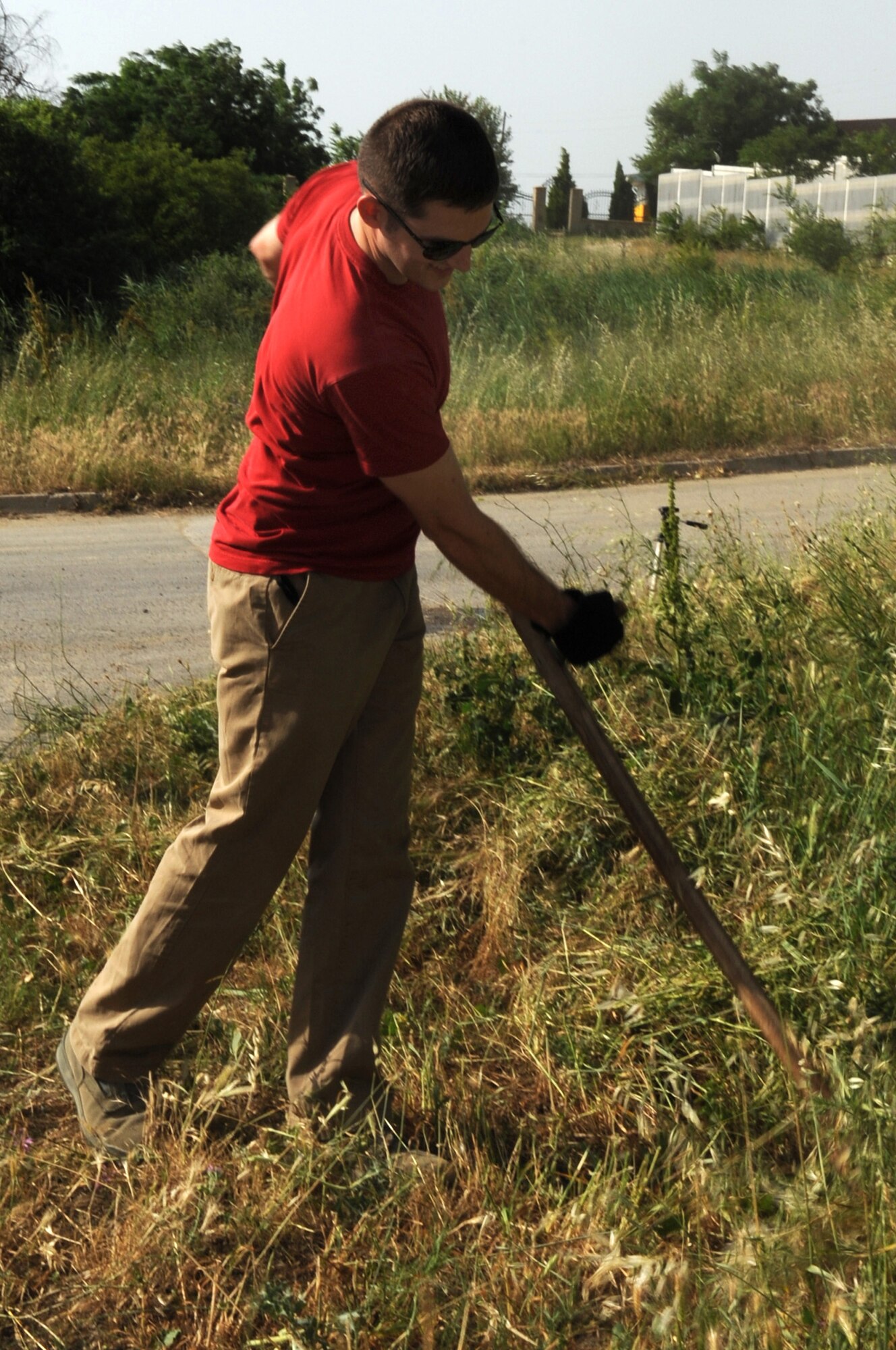 CAMP PEPELISHTE, Macedonia -- First Lt. Sean Ketterick, 31st Medical Support Squadron out of Aviano Air Base, Italy, uses a traditional Macedonian sickle to cut the grass along the side of a road in Negotino, Macedonia, during the Medical Training Exercise in Central and Eastern Europe 2011 volunteer day June 8. An annual Chairman of the Joint Chiefs of Staff-sponsored regional and multilateral exercise, MEDCEUR is designed to provide medical training and operational experience in a deployed environment for U.S. and partner nations. The countries participating in this year’s MEDCEUR are Macedonia, Montenegro, Bosnia and Herzegovina, Serbia, Slovenia and Norway.  The exercise will include both classroom and hands-on training and run until June 15. (U.S. Air Force photo/Staff Sgt. Nadine Y. Barclay)