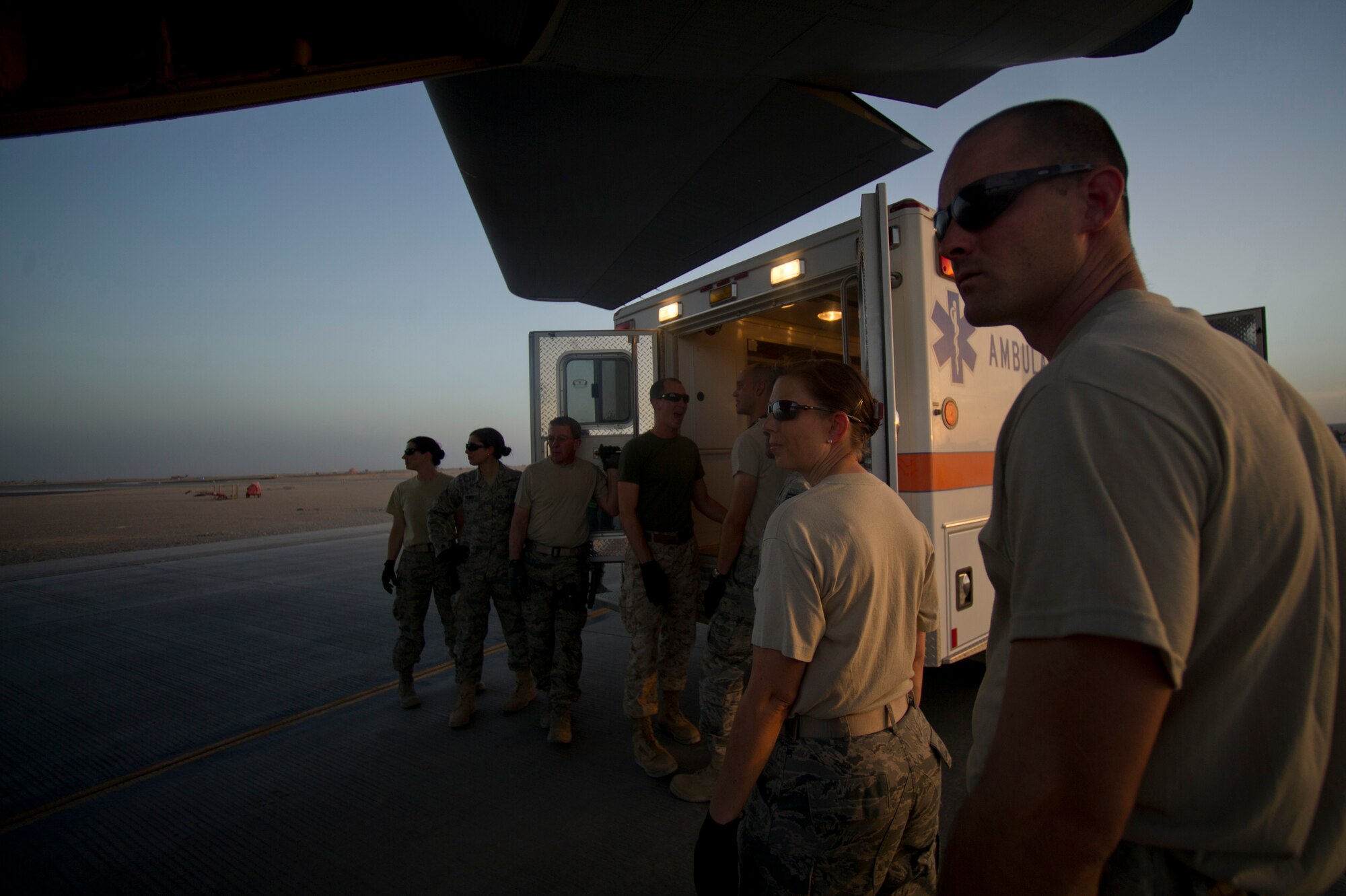 Members from the 451st Expeditionary Aeromedical Evacuation Squadron Detachment 1 Contingency Aeromedical Staging Facility wait to unload a wounded Marine off an ambulance and onto a C-130 Hercules at Camp Bastion, Afghanistan. The CASF team is responsible for taking care of and transporting patients from the staging facility and role hospital to aircraft who are then transported to the next level of medical care. (U.S. Air Force photo by Master Sgt. Adrian Cadiz)