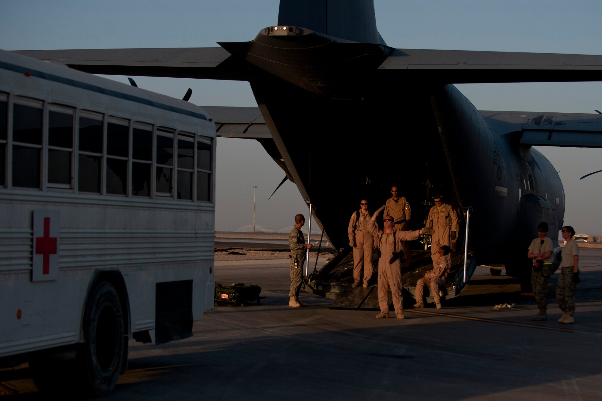 A member from the 451st Expeditionary Aeromedical Evacuation Squadron Aeromedical Evacuation Operations Team, directs an ambulance bus into place at Camp Bastion, Afghanistan in order to load injured personnel onto a C-130 Hercules. Members of AEOT work closely with the contingency aeromedical staging facility who are responsible for taking care of and transporting patients from the staging facility and role hospital to aircraft who are then transported to the next level of medical care. (U.S. Air Force photo by Master Sgt. Adrian Cadiz)
